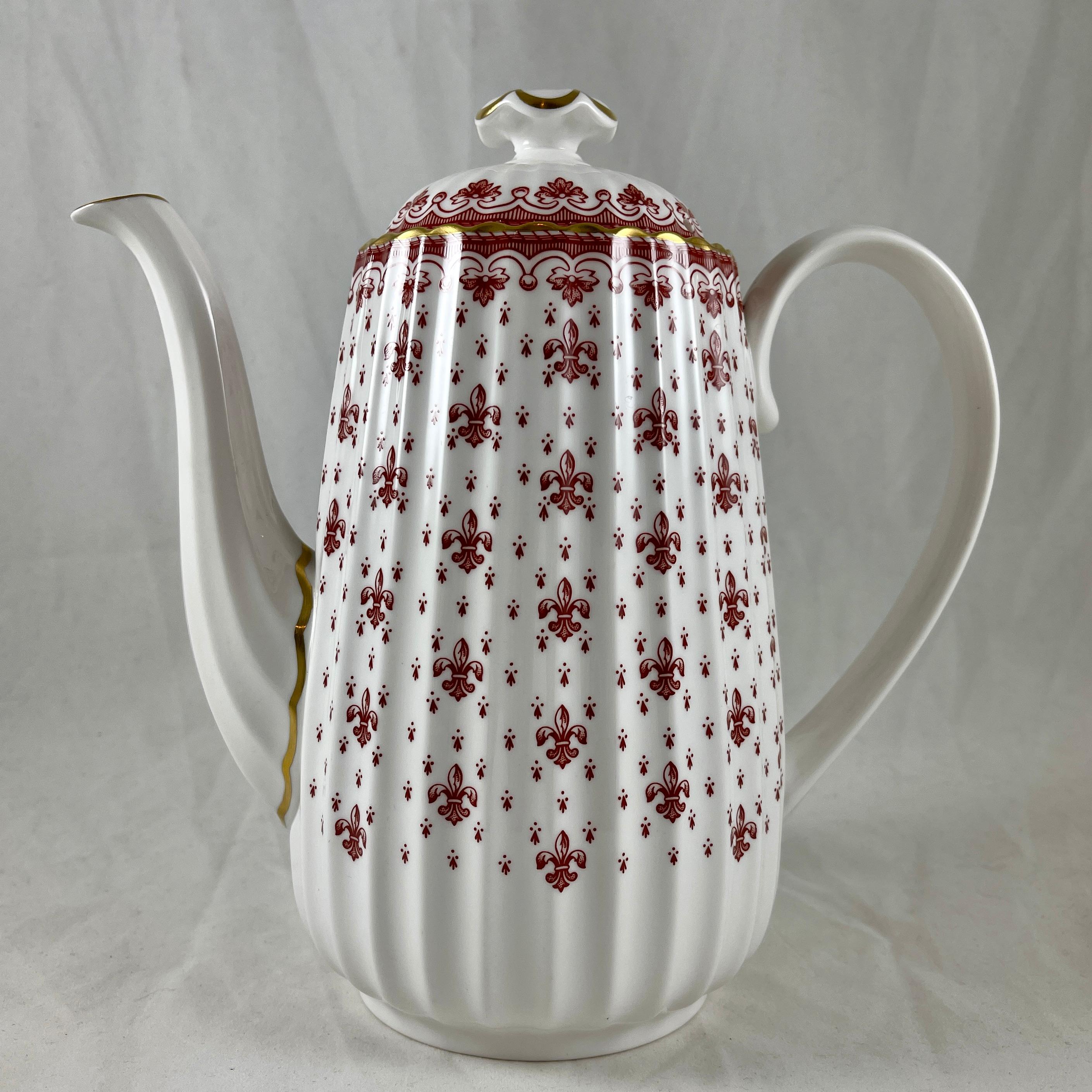 From Spode, England, a Fleur De Lys-Red Coffee Pot in the fluted Chelsea shape.

The Fleur de Lys pattern was introduced in 1961 and remained active until 1994, now discontinued.

A bone china coffee pot and lid, transfer printed in a
