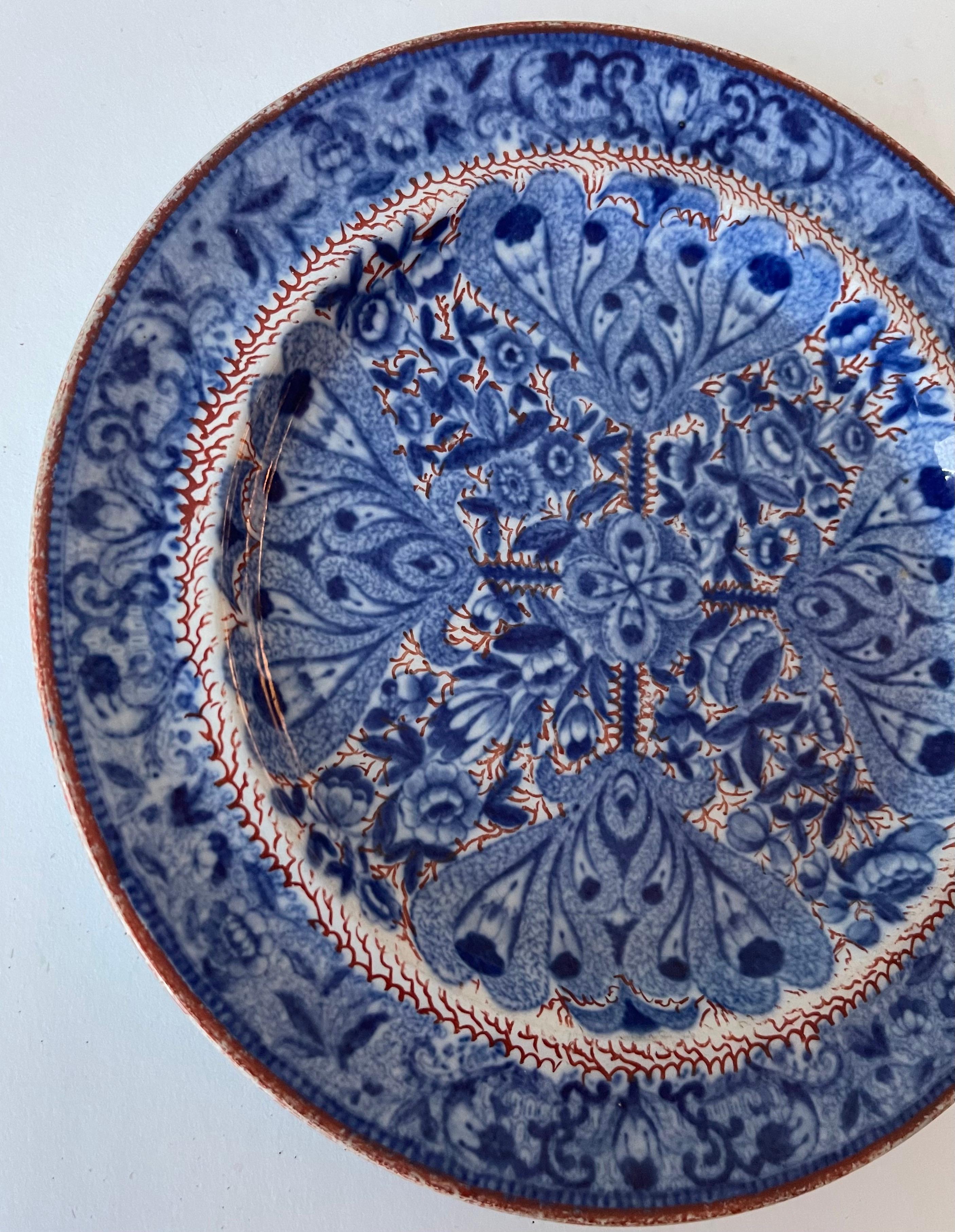 Spode Flower Cross Clobberware plate. Blue and white flower cross pattern with hand painted orange squiggle detailing. No makers mark or brand stamp. 