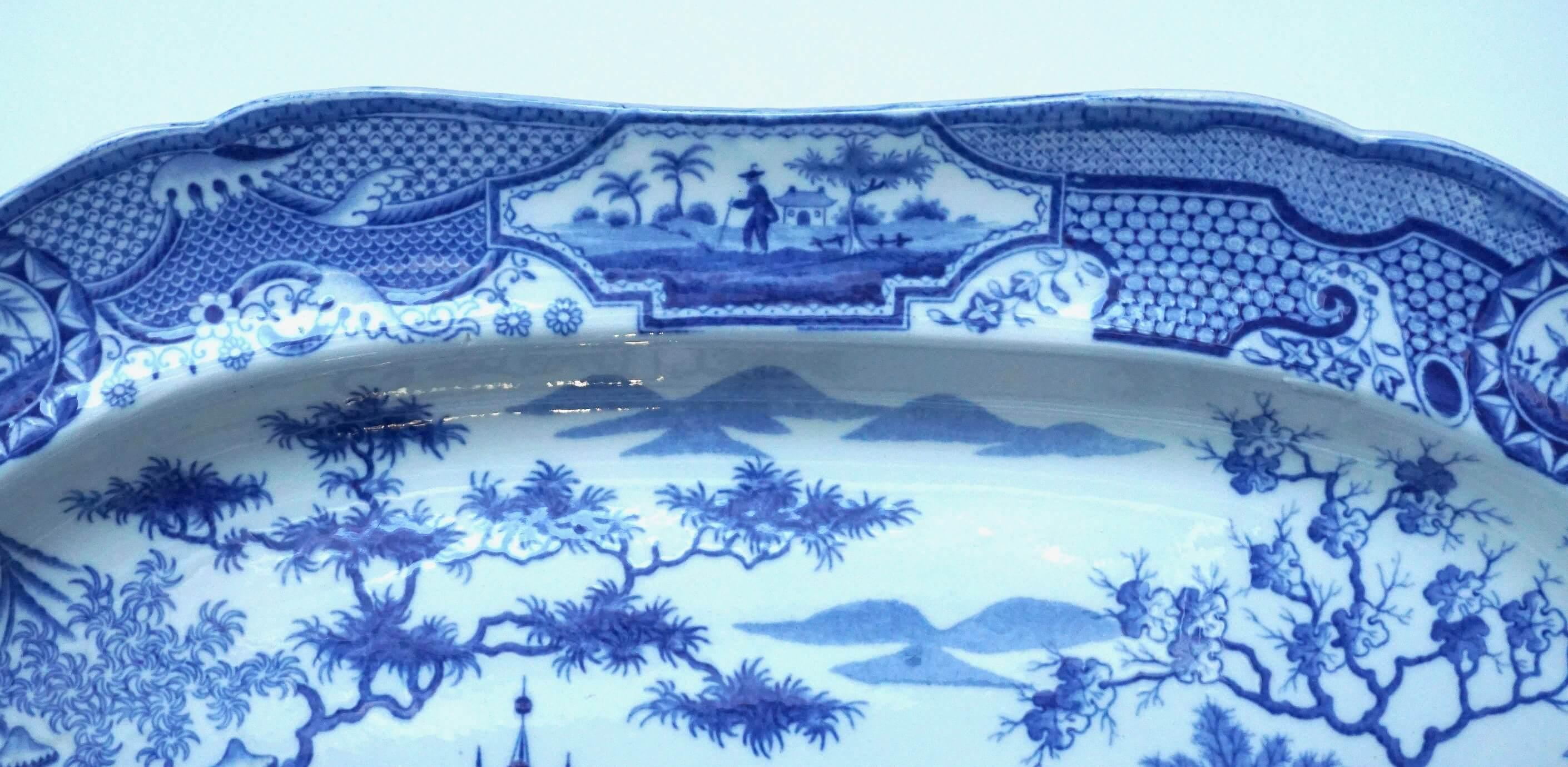 A large circa 1815 blue and white Staffordshire transferware platter produced by Spode in the 'Gothic Castles' pattern having shaped body with underglaze transfer printed decoration, the central reserve having Gothic castle in an Oriental garden