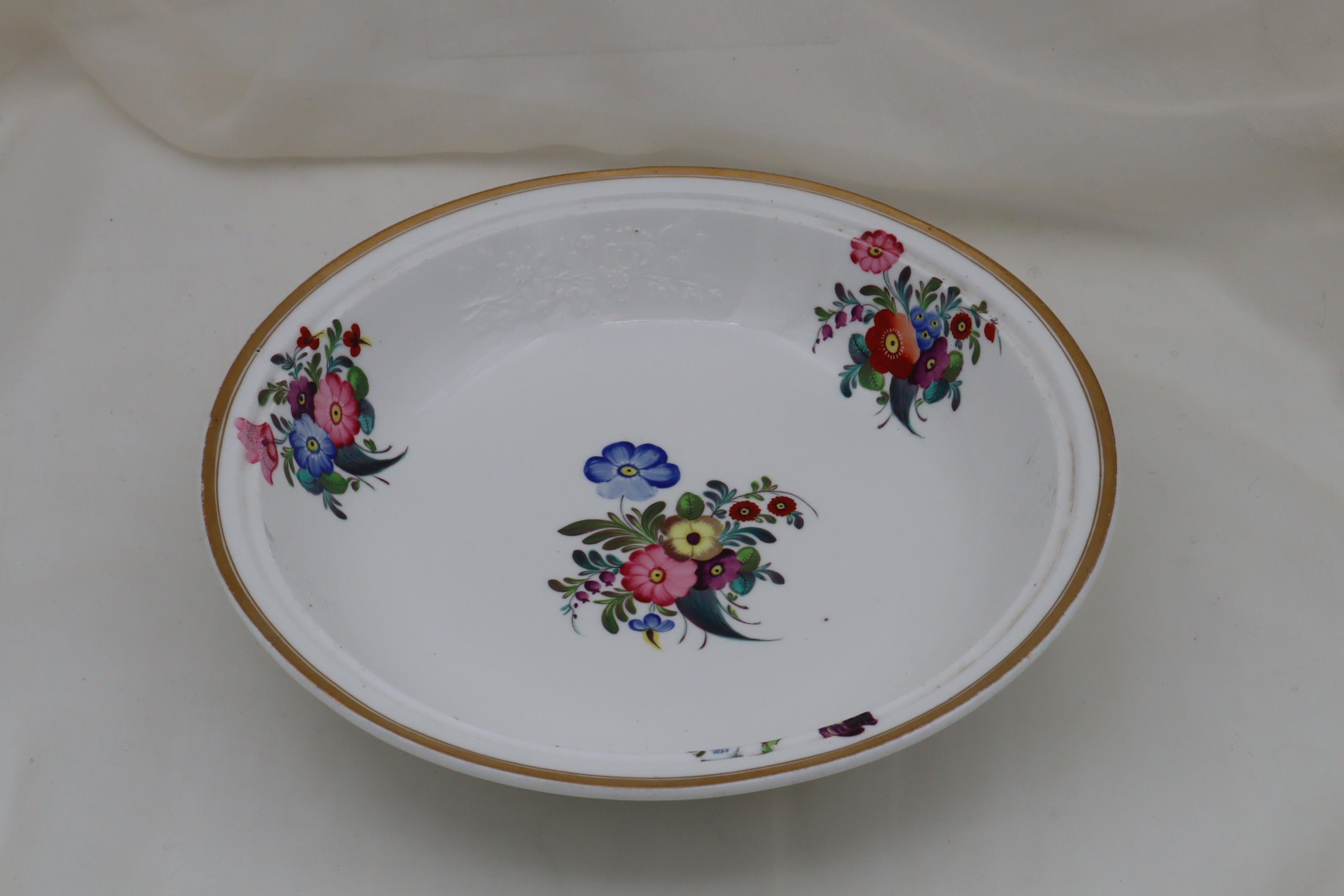 This Spode hand painted and gilded vegetable tureen is decorated around the rim of both the body and the lid, with three moulded sprays of flowers left in the white, and between them are a further three hand painted sprays. There is also a larger