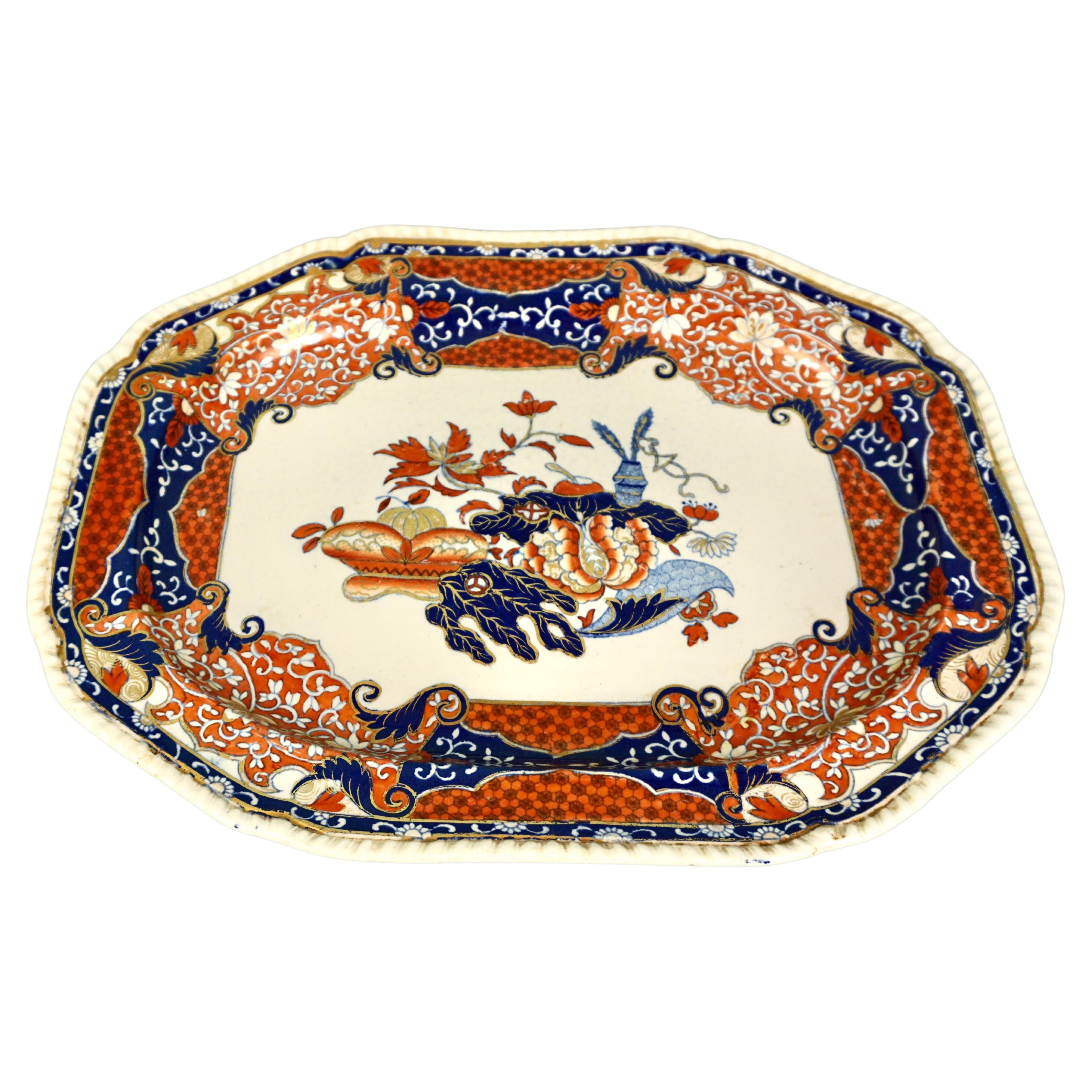 A beautiful English Victorian period Spode porcelain platter of large Size, elaborately decorated with stylized flowers, fruits, leaves and vegetables in blues and reds on a white field with gilt highlights. The pie crust perimeter complements the