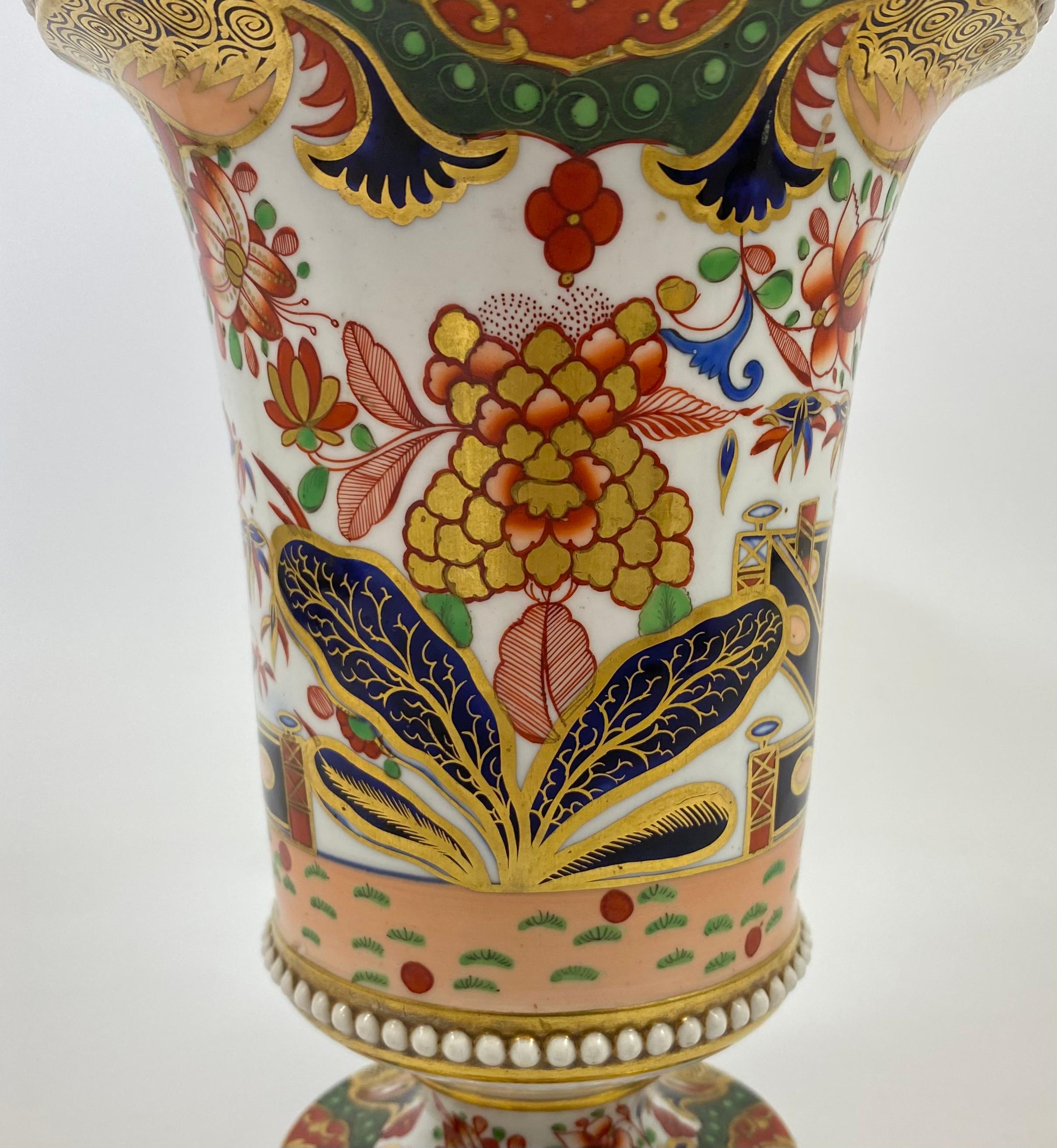 An outstanding and rare Spode porcelain garniture of spill vases, c. 1810. Each vase beautifully painted in pattern number ‘967’ with a continuous Imari style design of flowering plants, before a fence, in a garden setting, beneath elaborate scroll