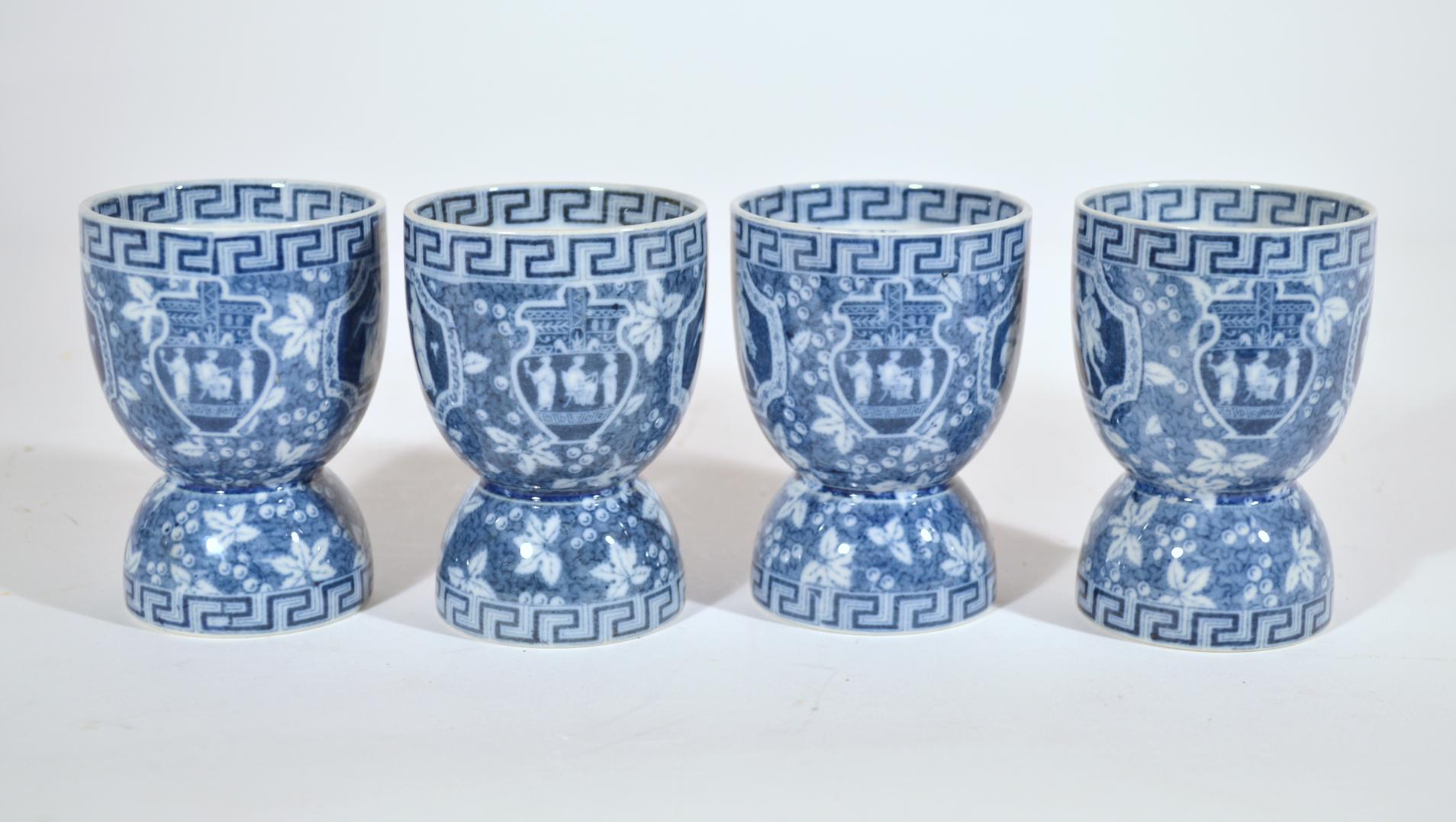 Spode pottery blue Greek pattern double egg cups
late 19th century

The double Spode egg cups have a Greek key design to top and bottom. To one side is a panel with three seated musicians and to the other side are three minstrels playing their