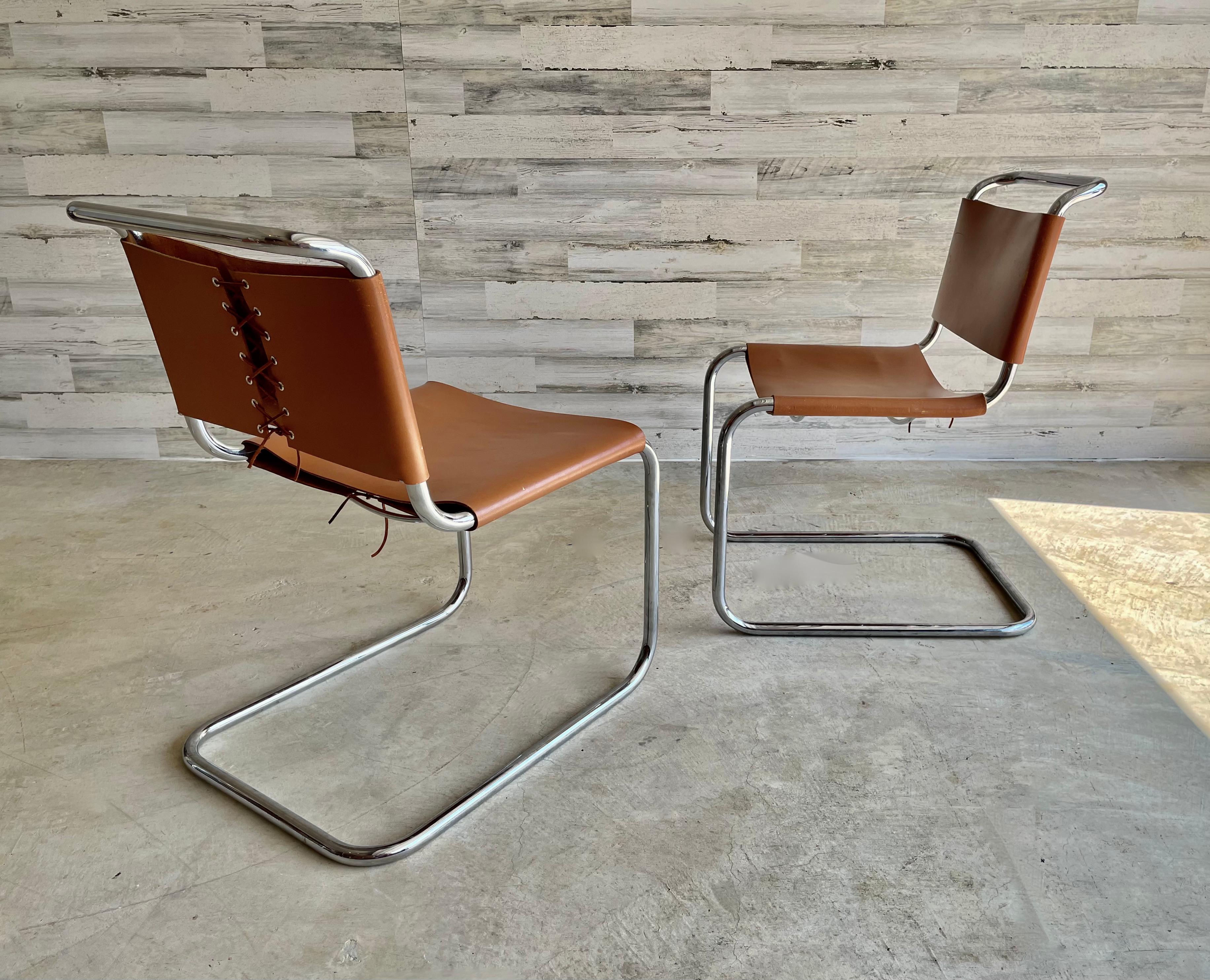 Spoleto dining/ side chairs attributed to Knoll. Chrome cantilever chairs with a cognac/ carmel color leather that is laced with kodiak leather lace.