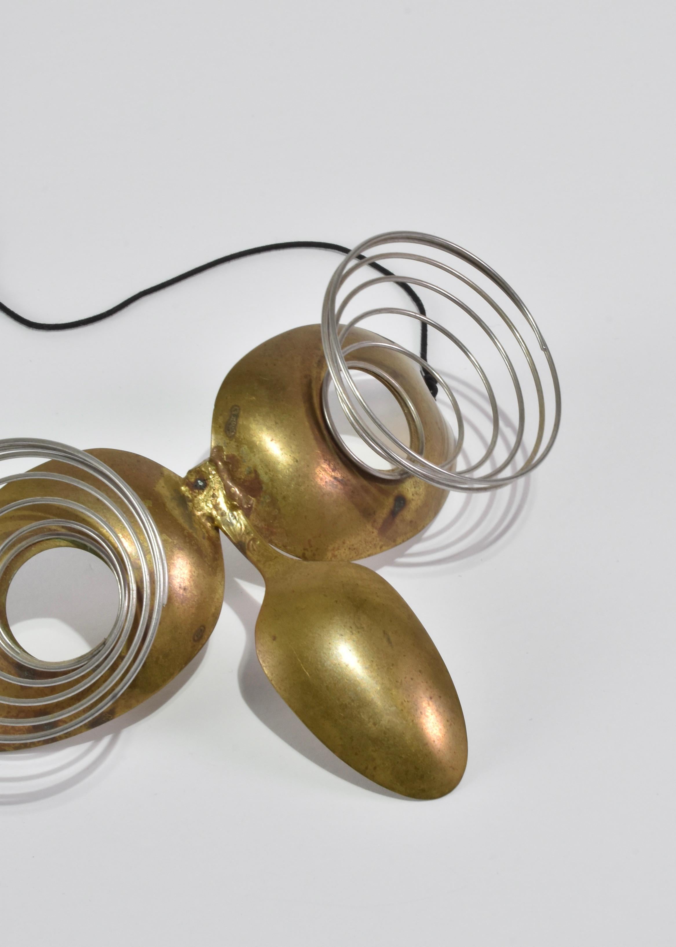 Maschera in ottone lavorata a mano con occhi a spirale e timbro Spoonman.