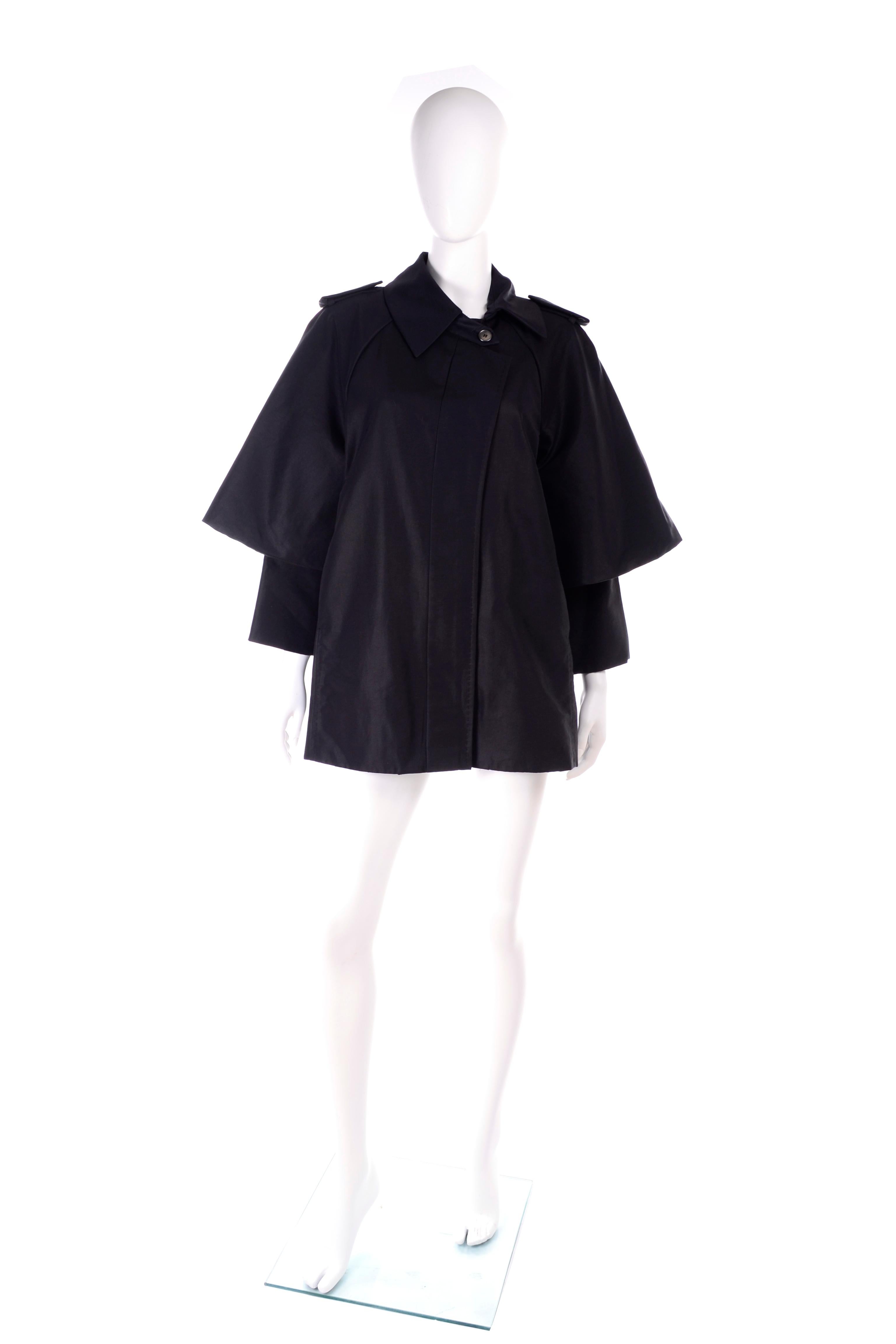 This is the perfect raincoat! This Sportmax jacket has epaulets on the shoulders and a lovely capelette attached overlay. It zips closed with one button at the collar, and there is a small gemstone on the back collar. 

100% silk lining and 60%