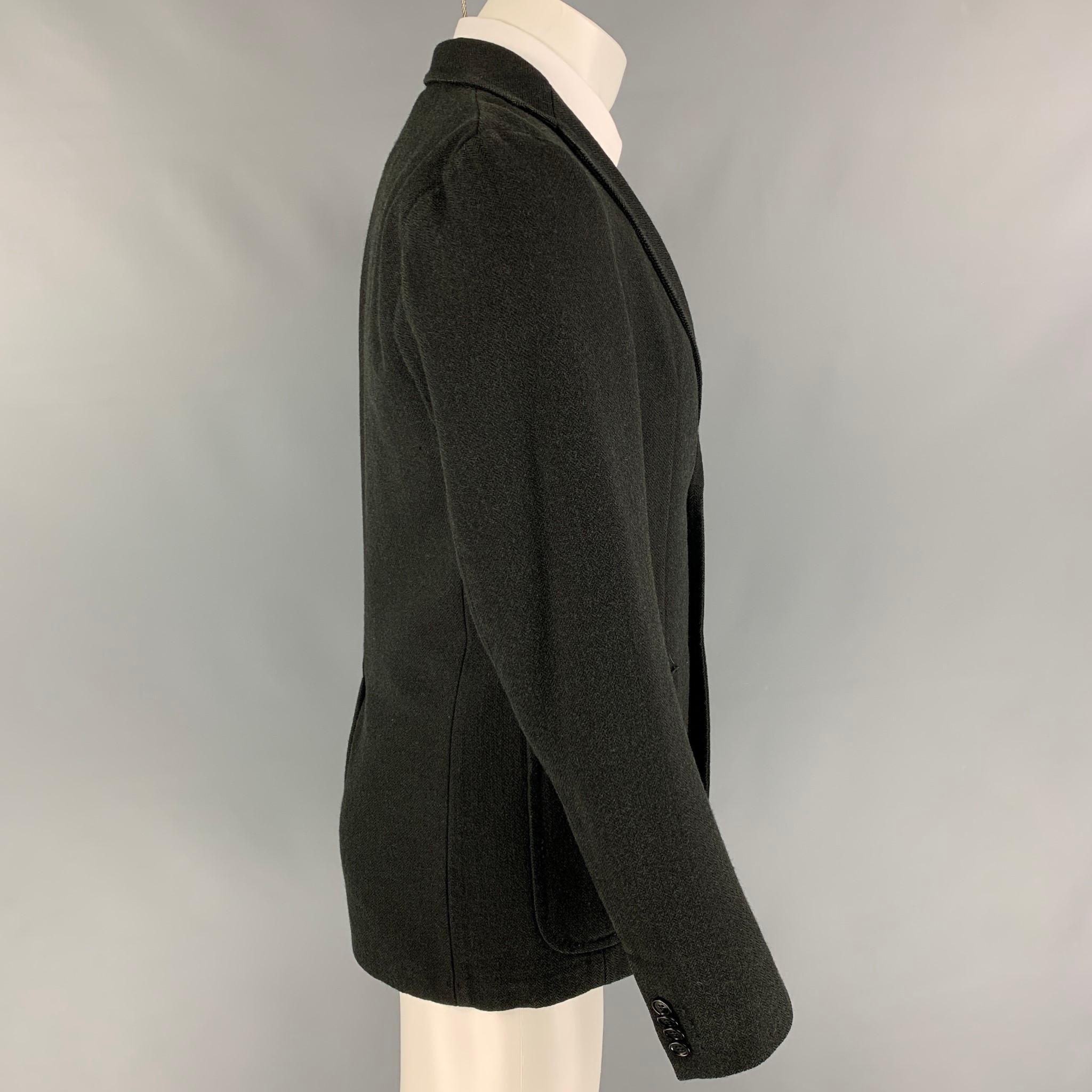 SPORTSWEAR COMPANY S.P.A sport coat comes in a black herringbone wool with a full liner featuring a notch lapel, patch pockets, single back vent, and a double button closure. Made in Italy. 

Very Good Pre-Owned Condition.
Marked: 48
Original Retail