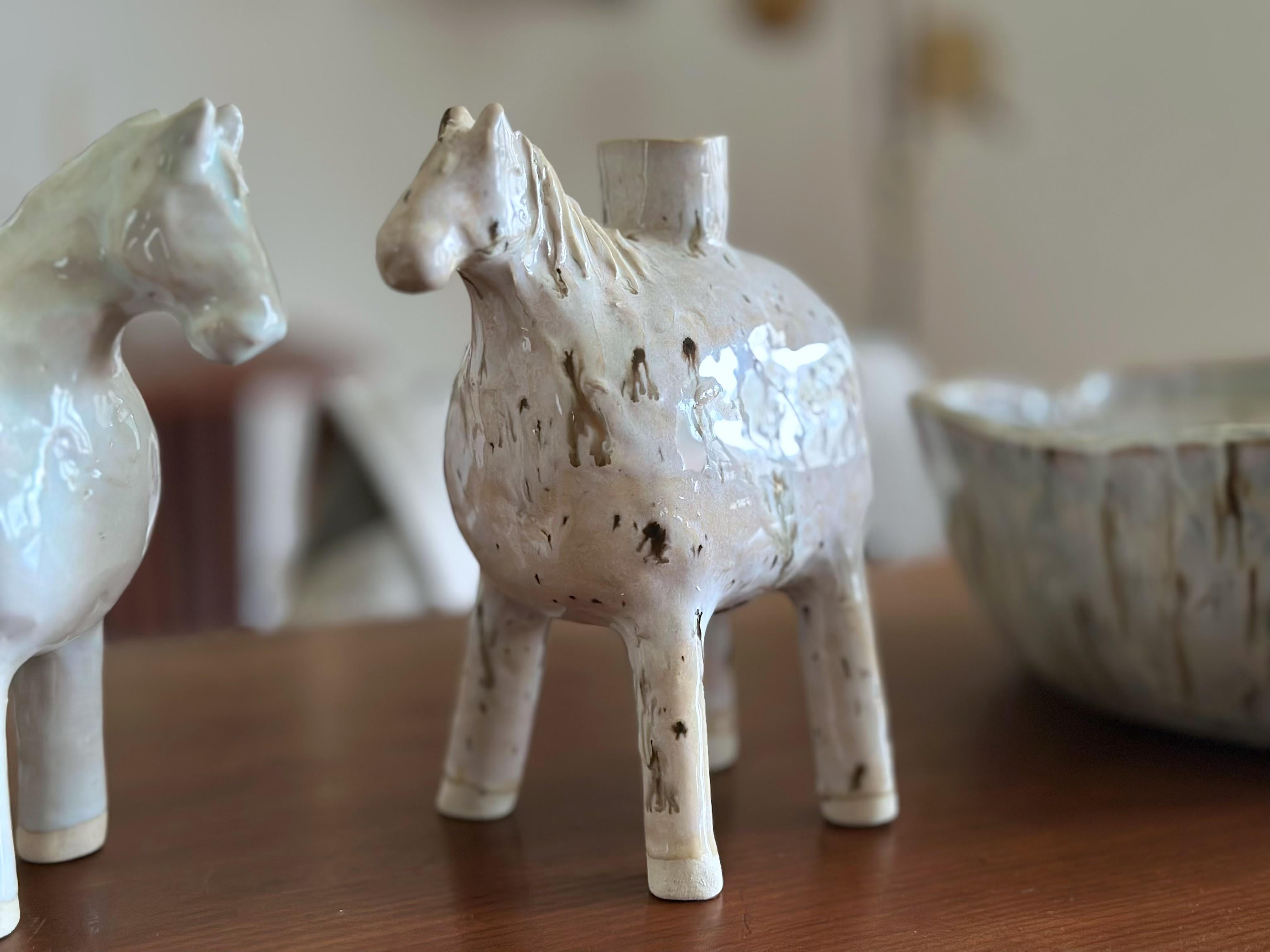 JESSE FALES, Vase à cheval crème tacheté, grès blanc et glaçure, 2024. 

Ce vase ou bougeoir artisanal évoque la simplicité, la force et la pureté du cheval blanc. Fabriqué à la main dans la région de Yellowstone.  Fait à la main ; chaque pièce est