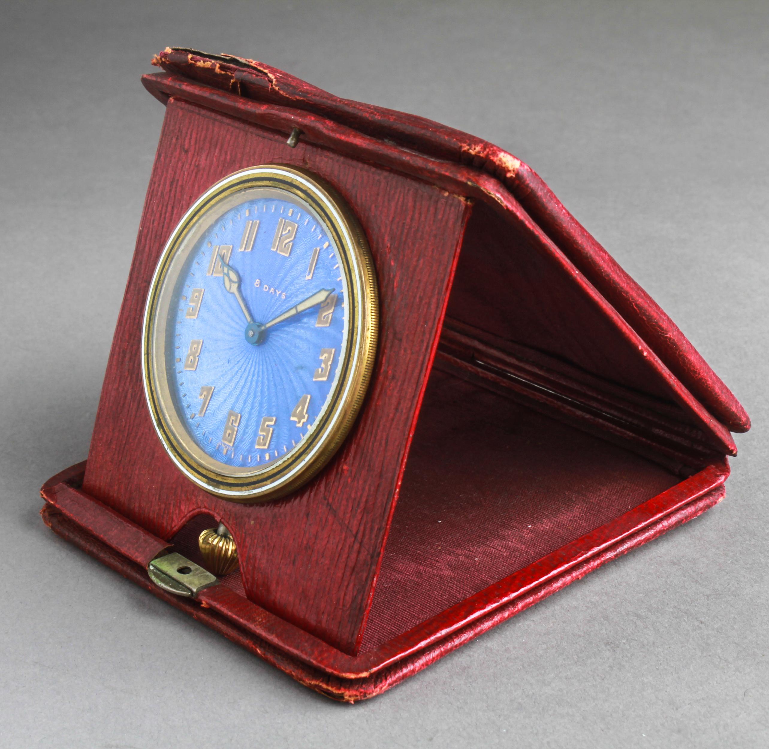 Swiss eight-day travel clock with a decorative blue guilloche enamel dial and painted hands and numerals. The dial is marked 