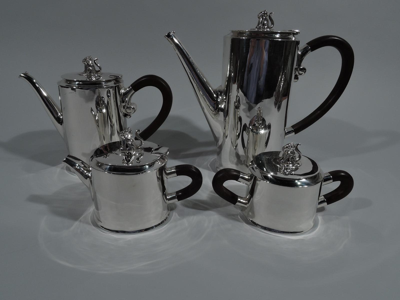 Modern sterling silver coffee and tea set. Made by Spratling in Taxco. Each: Ovoid body and stained-wood scroll handle and flat cover with tooled finial in form of seated jaguar– an exotic touch to a spare form. A smart design by the famed Mexican