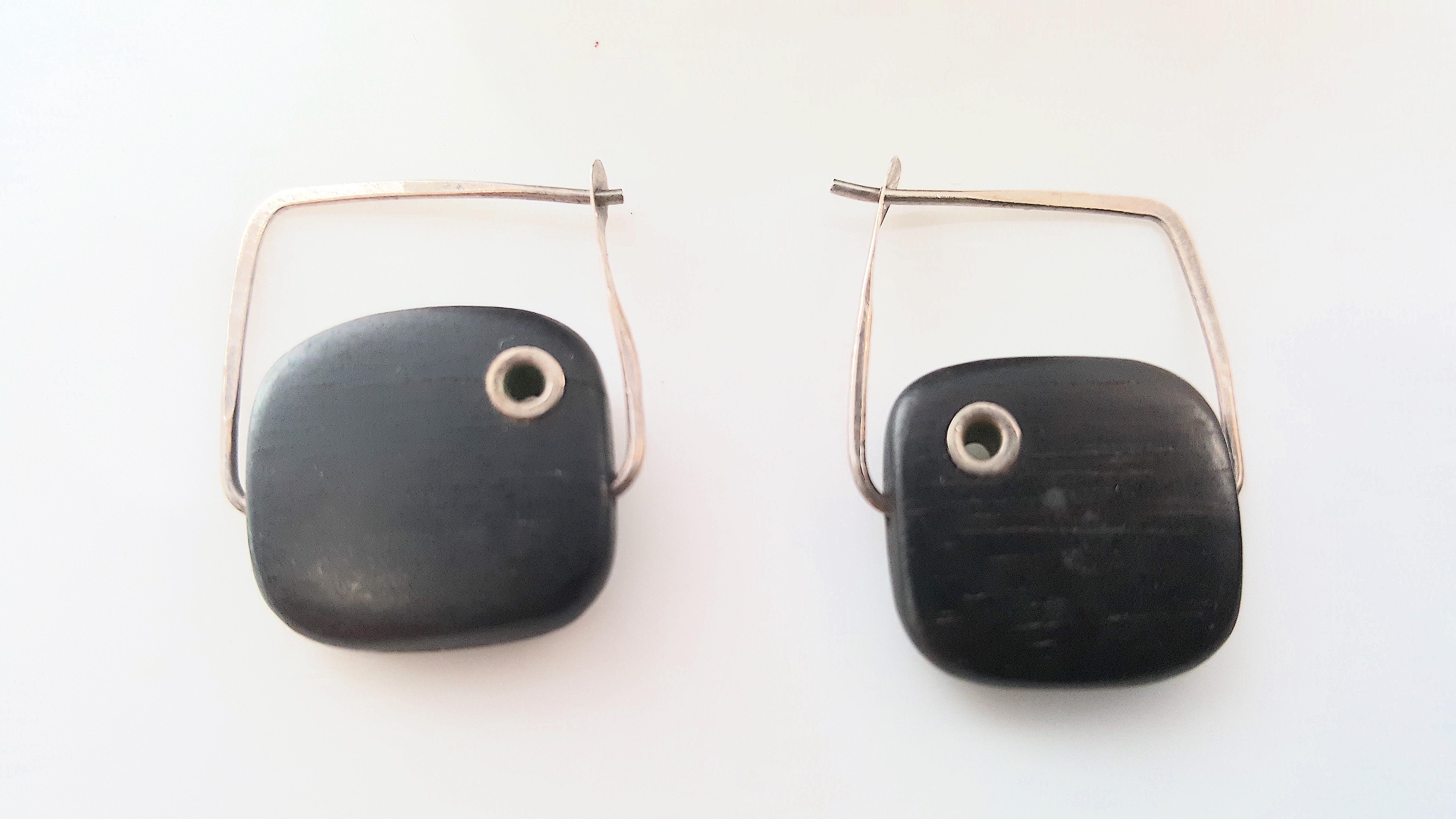 Epitomizing William Spratling's use of sterling silver inlay, ebony wood, geometric shapes, minimal decoration, hand-hammering, and Art-Deco inspiration, these modern hoop-like earrings feature black gradient-stain cubes that are each masterfully