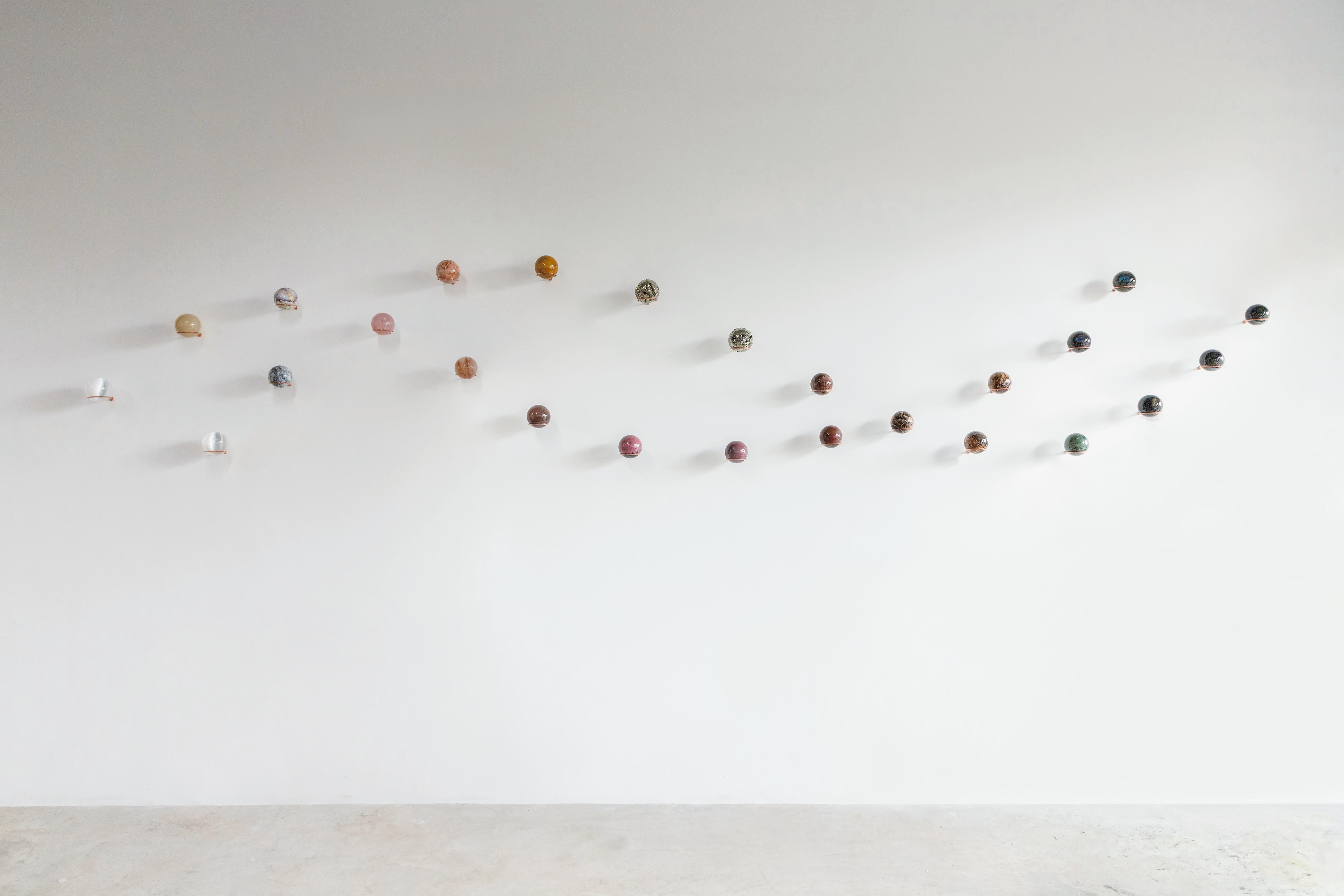 Semi-precious stones, metal holder
Composition dimensions: 157.4” W x 4.2” D x 29.1” H / 400 W X 10.9 D x 74 H cm
Edition of 15
Set of 25 spheres

**We can custom color pallet in the composition**

Galaxies are systems where stars, dust, and dark