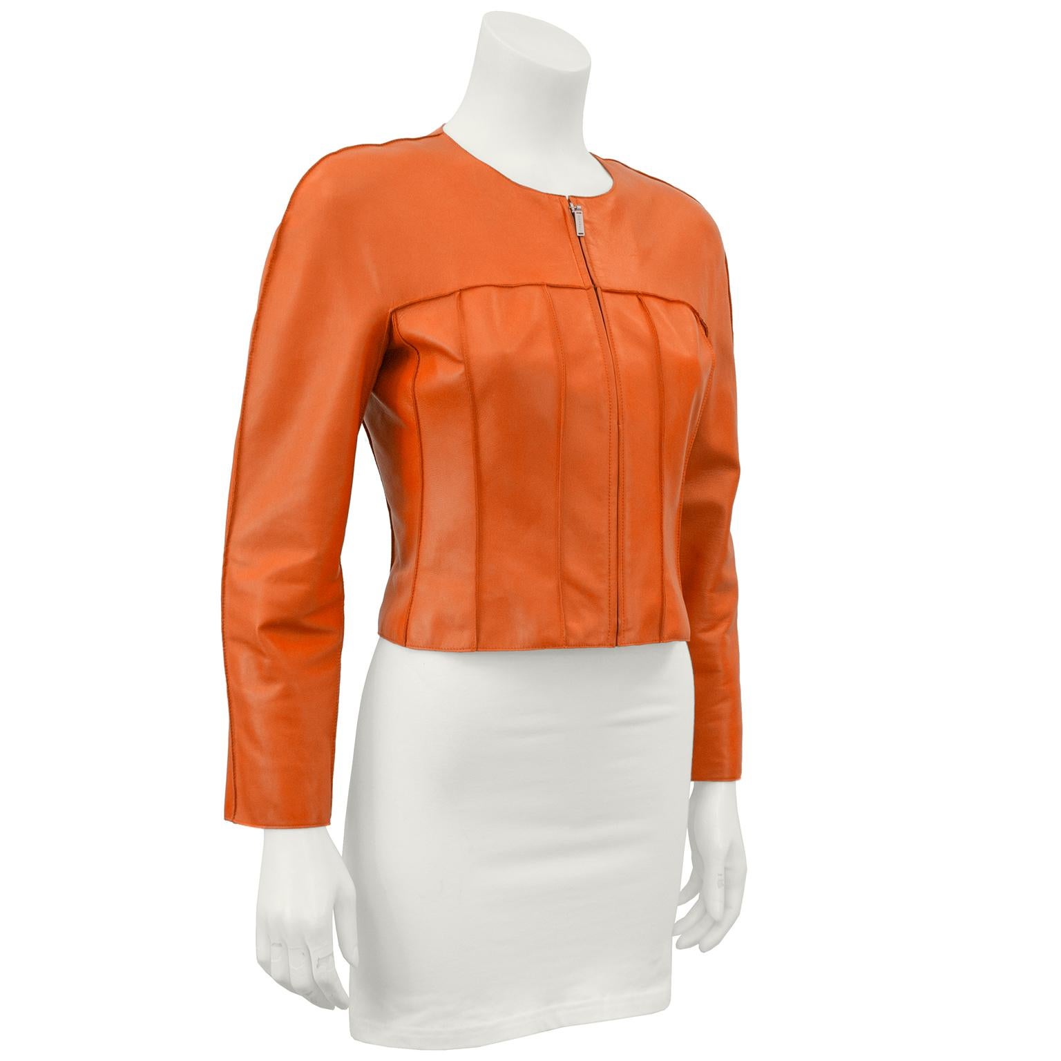 Orange lambskin cropped leather jacket from Chanel Spring 1999 collection. The jacket has a slightly structured shoulder, zipper up the front, rounded neckline and vertical seam detail throughout the body. Fully lined in branded orange silk, CHANEL