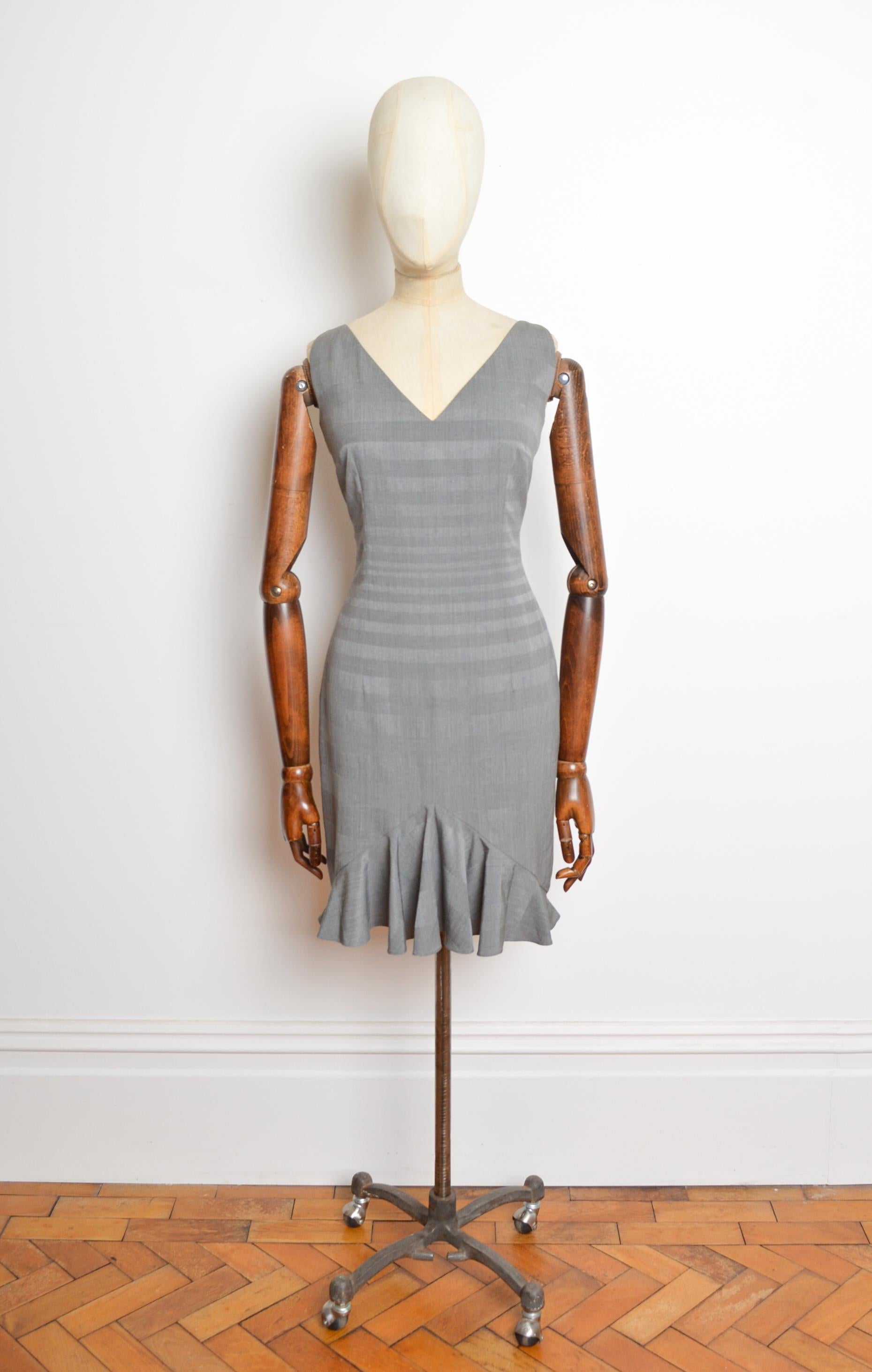 Un decadente abito della primavera 1999 di John Galliano for Christian Dior in un pudico damier di lana grigio, con interni foderati in pura seta, silhouette aderente, zip nascosta sulla schiena e orlo al ginocchio.
PRODOTTO IN FRANCIA.
Taglia