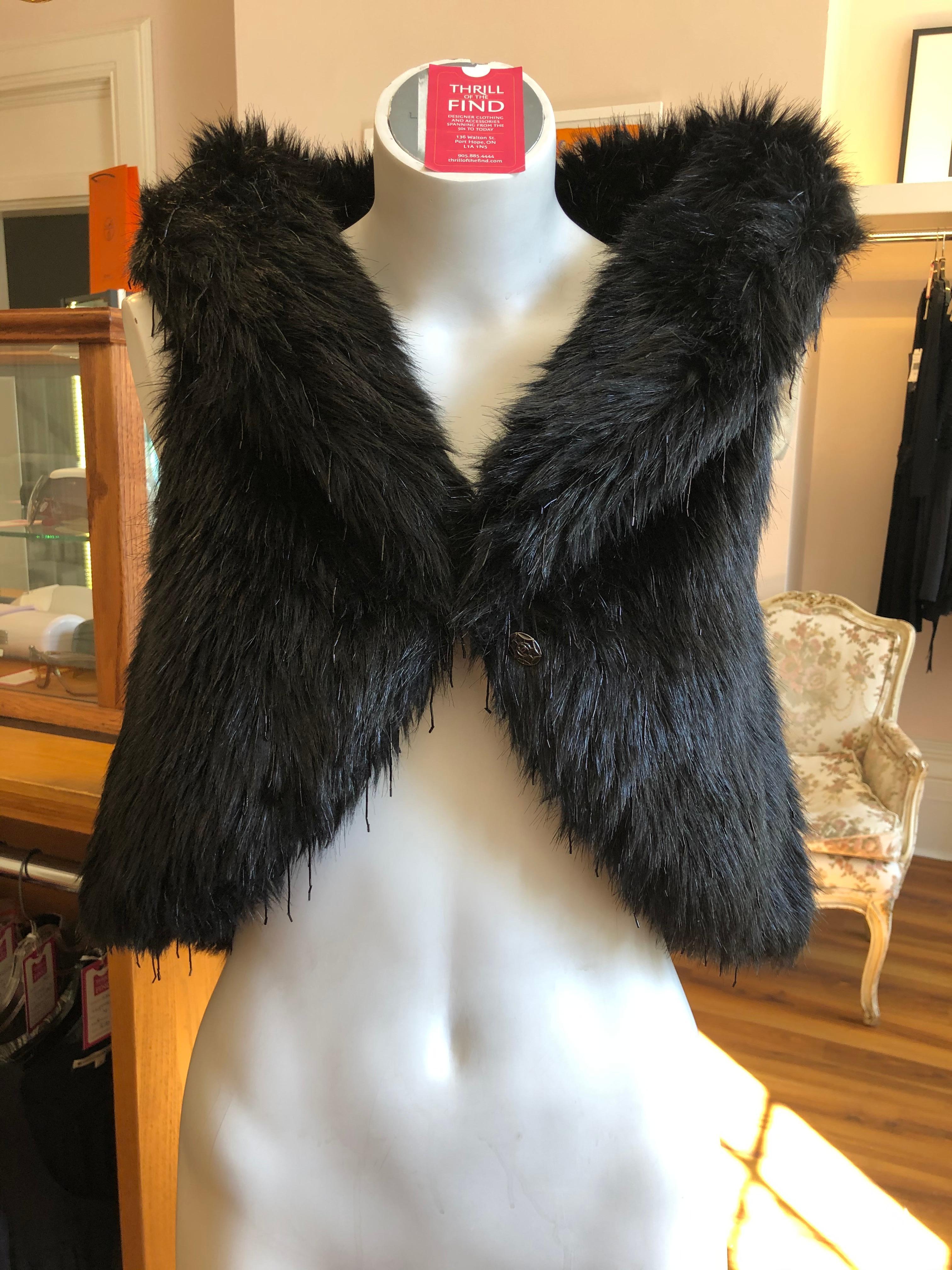 Never worn and with part of the tag still intact, as per picture, this Chanel black faux fur has a collar which can be put up or down; a CC logo button, and hook and eye closure.  There is also lovely beading throughout.

This Chanel piece was