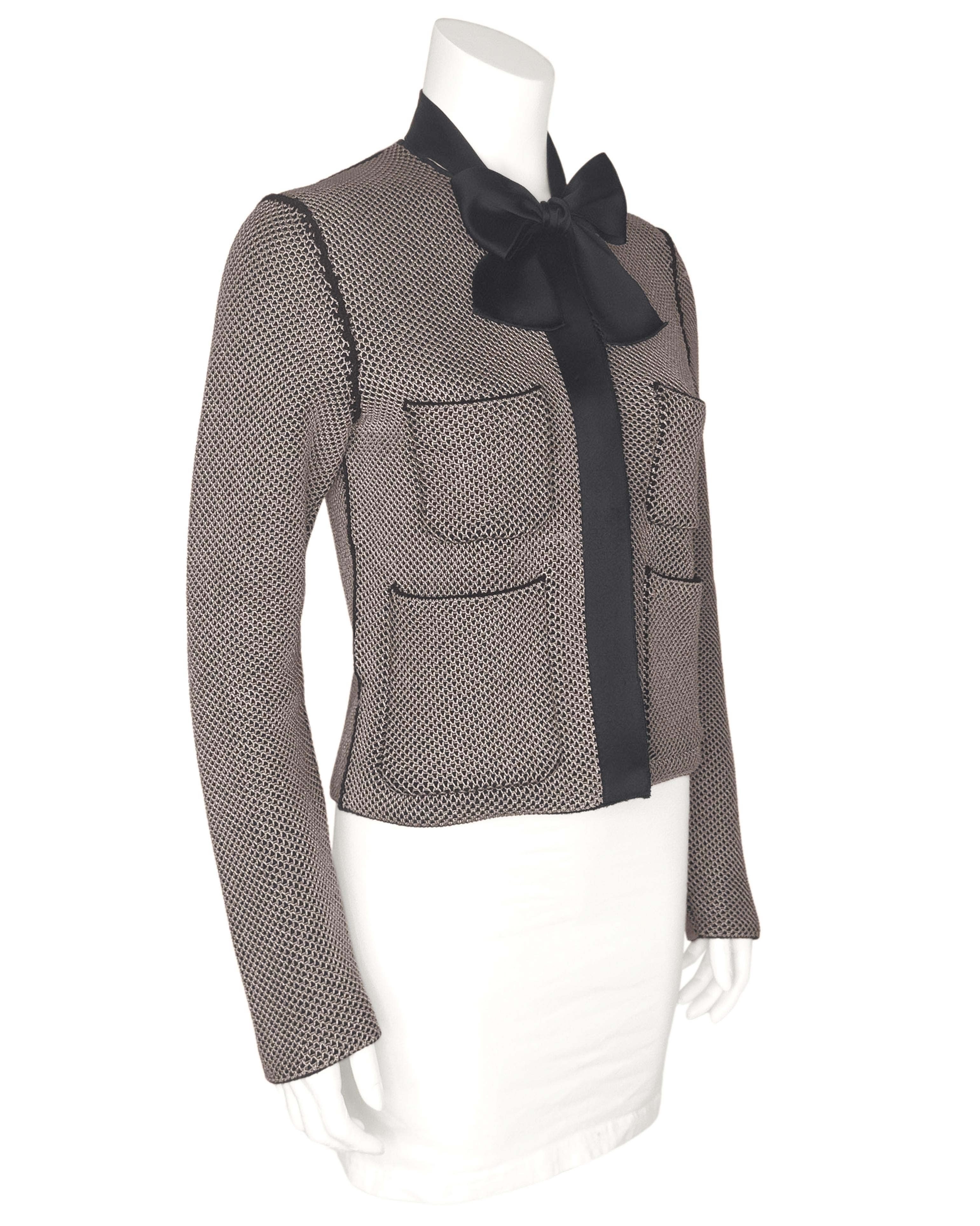 Chaqueta Louis Vuitton by Nicolas Ghesquière de la colección Primavera 2016. La chaqueta es de punto gofre de mezcla de lana merina negra y beige. El beige se asienta sobre el negro para dar un efecto de panal. Una corbata de satén de seda negro