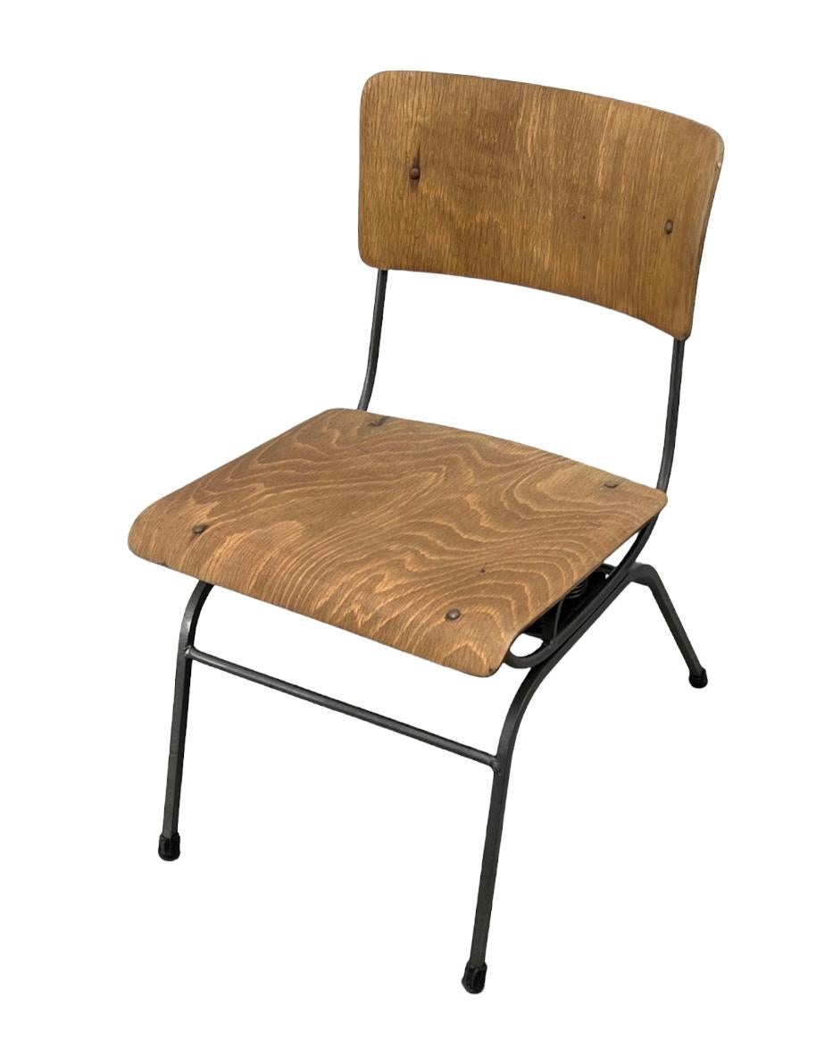 Chaise de salon américaine ancienne avec un caractère et une patine étonnants. La base en fer avec mécanisme à ressort permet un mouvement flexible. Les composants en contreplaqué moulé présentent un magnifique motif de grain de bois.