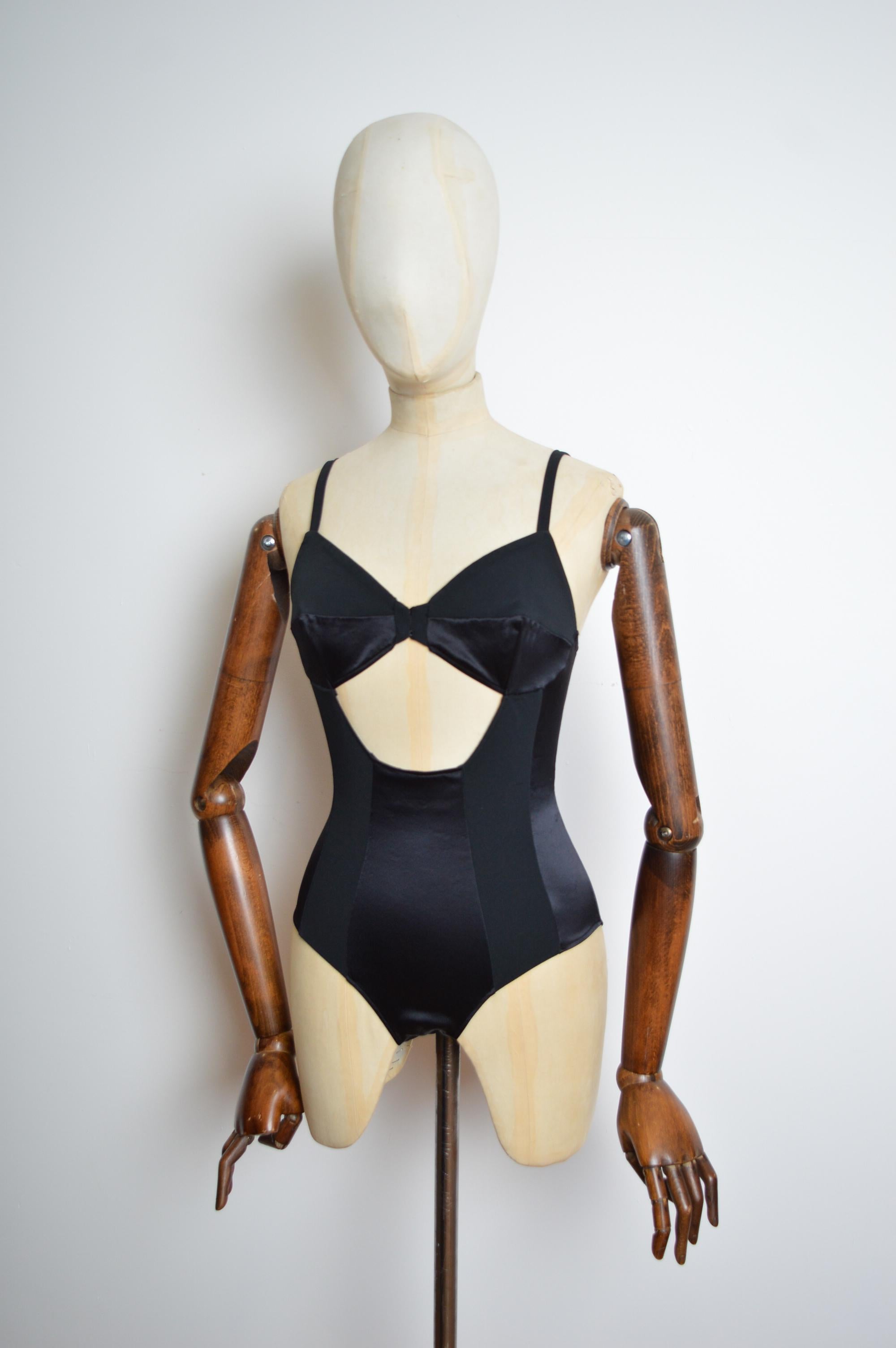 Splendido body da passerella primavera/estate 1993 realizzato in Silhouette nera con pannelli in Lycra elasticizzata per offrire una silhouette che abbraccia la figura e la forma. Caratterizzato da un seducente dettaglio cut-out sul davanti.