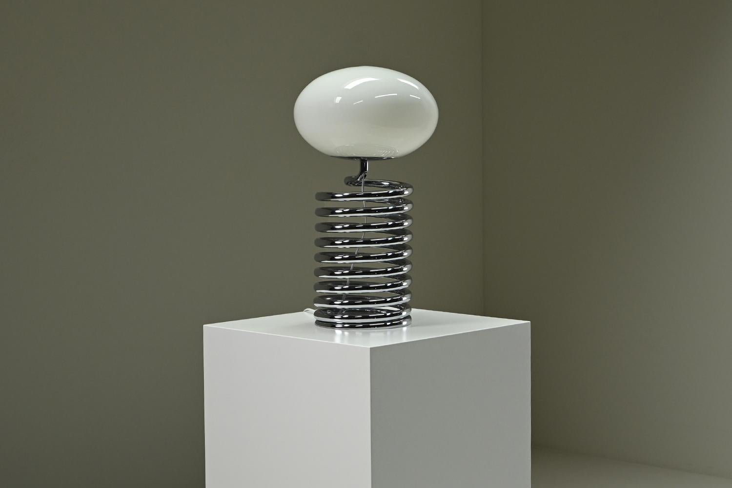 Lampe de table Spring d'Ingo Maurer pour Design M, années 1960, Allemagne. La lampe de table Spring associe une forme ludique à des matériaux raffinés, avec une base en spirale en chrome poli qui apporte une sensation de mouvement et de légèreté à