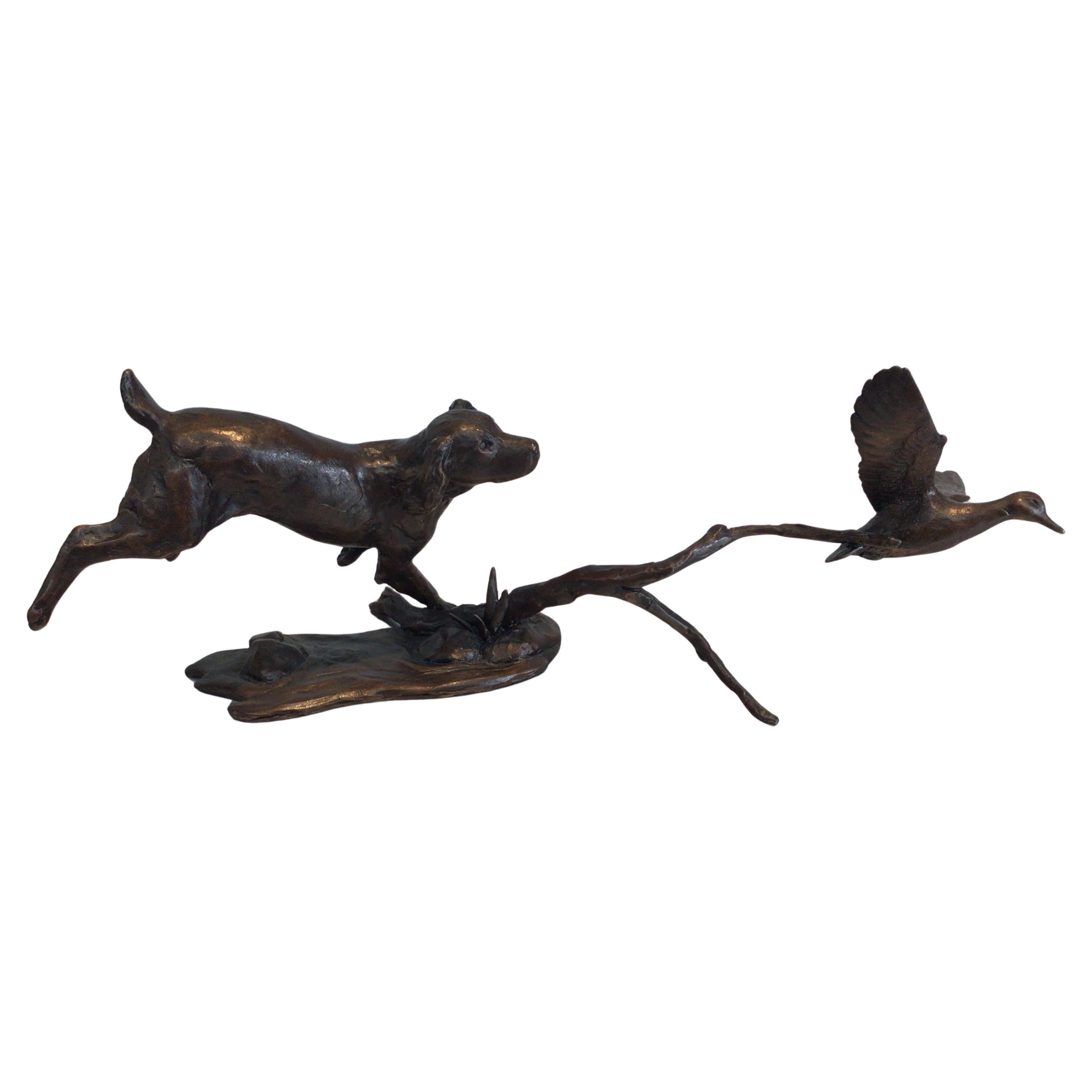 Questa raffinata scultura di Michael Simpson raffigura uno spaniel che insegue un'anatra in volo. Realizzato in bronzo massiccio e inciso con il marchio del produttore e il numero di edizione. La scultura presenta una patina rifinita a mano con