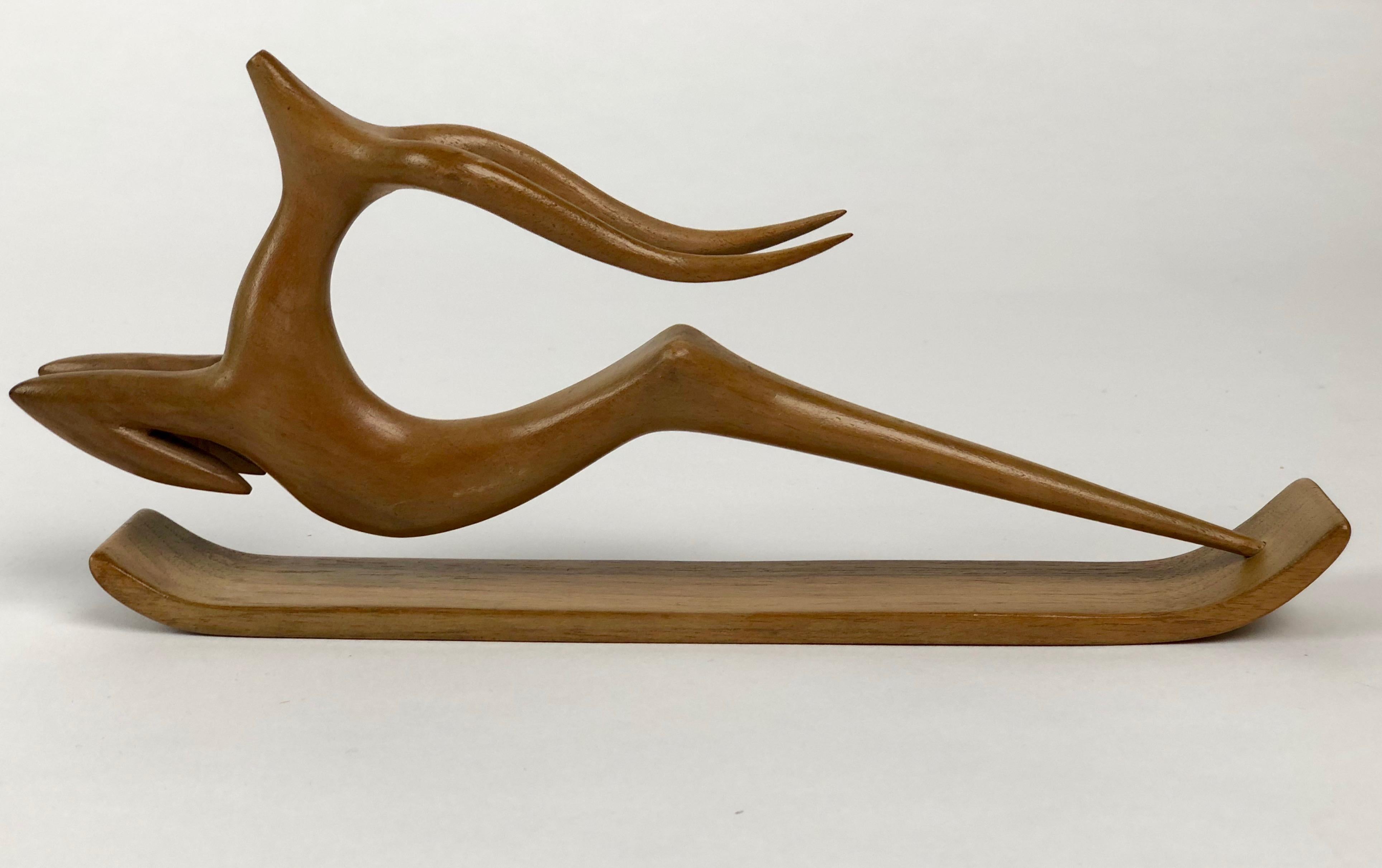 Wonderful springing gazelle sculpture designed and made in the Hagenauer Werkstätte Wien expertly carved from a single piece of wood includes the original base for display.