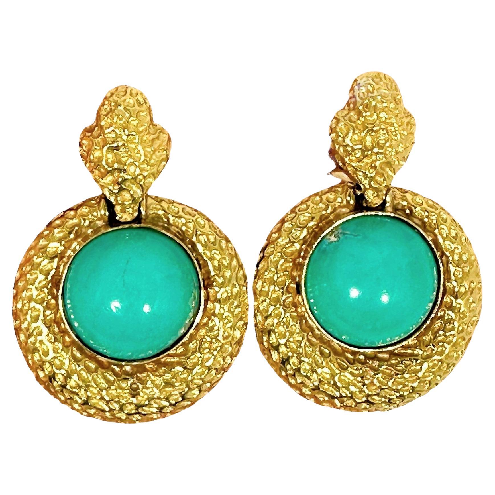 A pair of 1960’s Spritzer & Furhmann 18K yellow gold earrings, with a door knocker design. Each earring is set with one 18mm Persian turquoise cabochon. The contrasting rich gold and turquoise colors are brought together by a framework which is