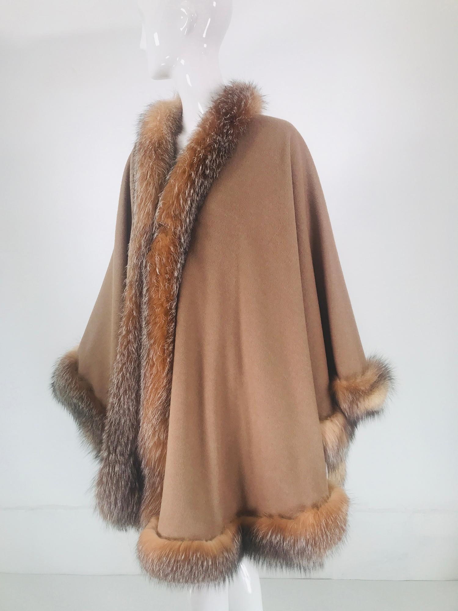 Sprung Freres Paris red fox trim, wool/cashmere blend reversible cape in grey or camel tan. A beautiful cape that is below hip length, it is full and trimmed in rare red fox. The cape is open at the front, there are no closures. 
The fabric is soft