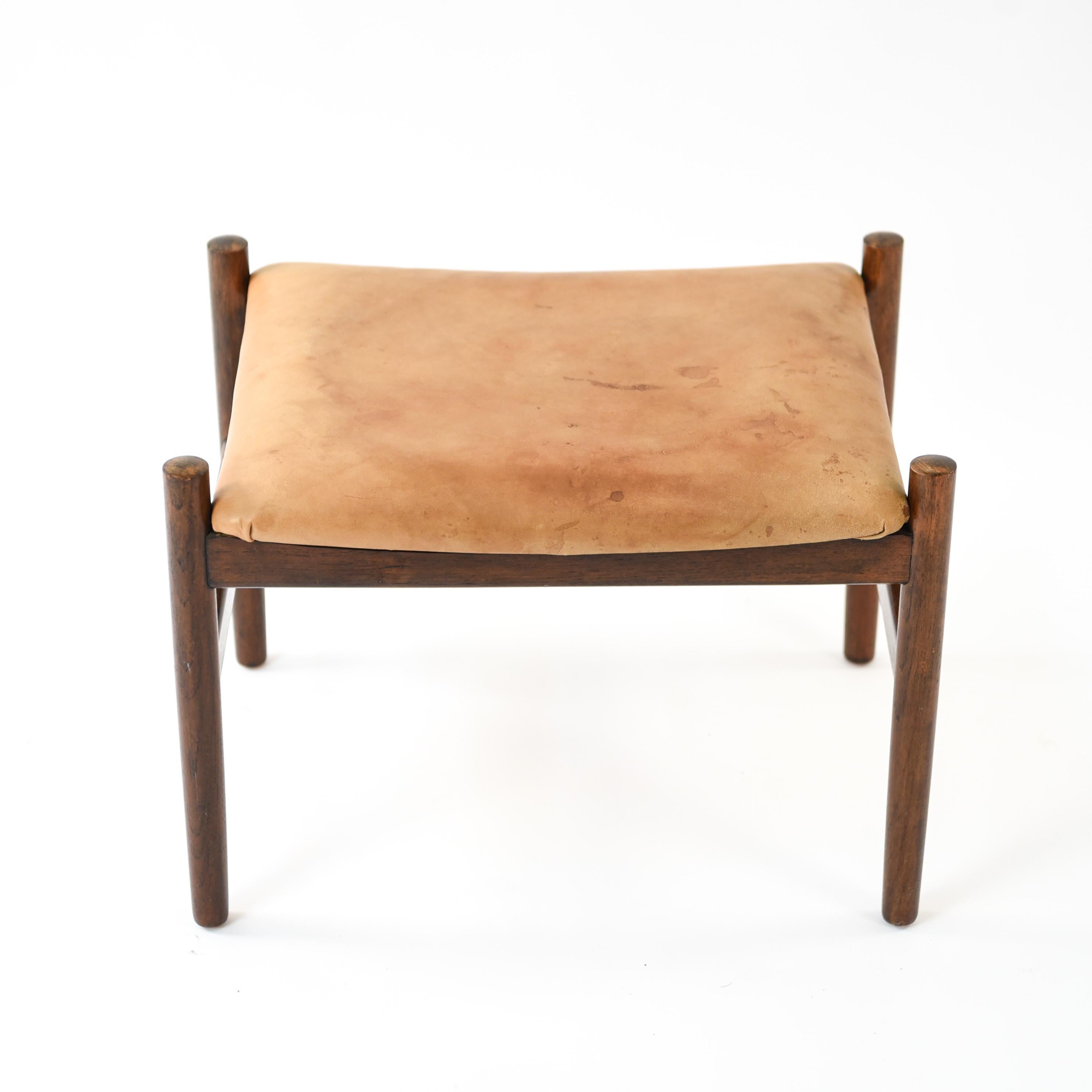 This is a nice little ottoman or stool by Danish midcentury manufacturer Spottrup Mobelfabrik. With leather upholstery that has original patina.