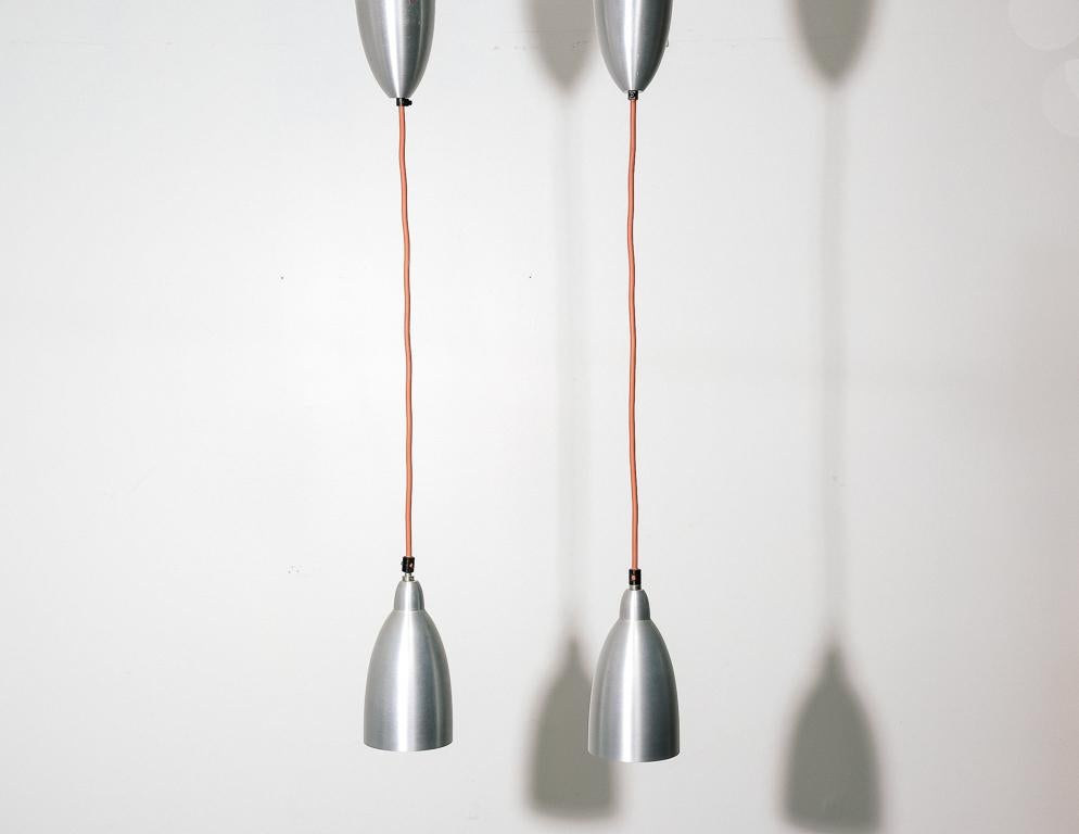 Vintage hanging lamps by Dijkstra, Holland. Spun aluminum shades with matching ceiling caps. Sold as a pair.