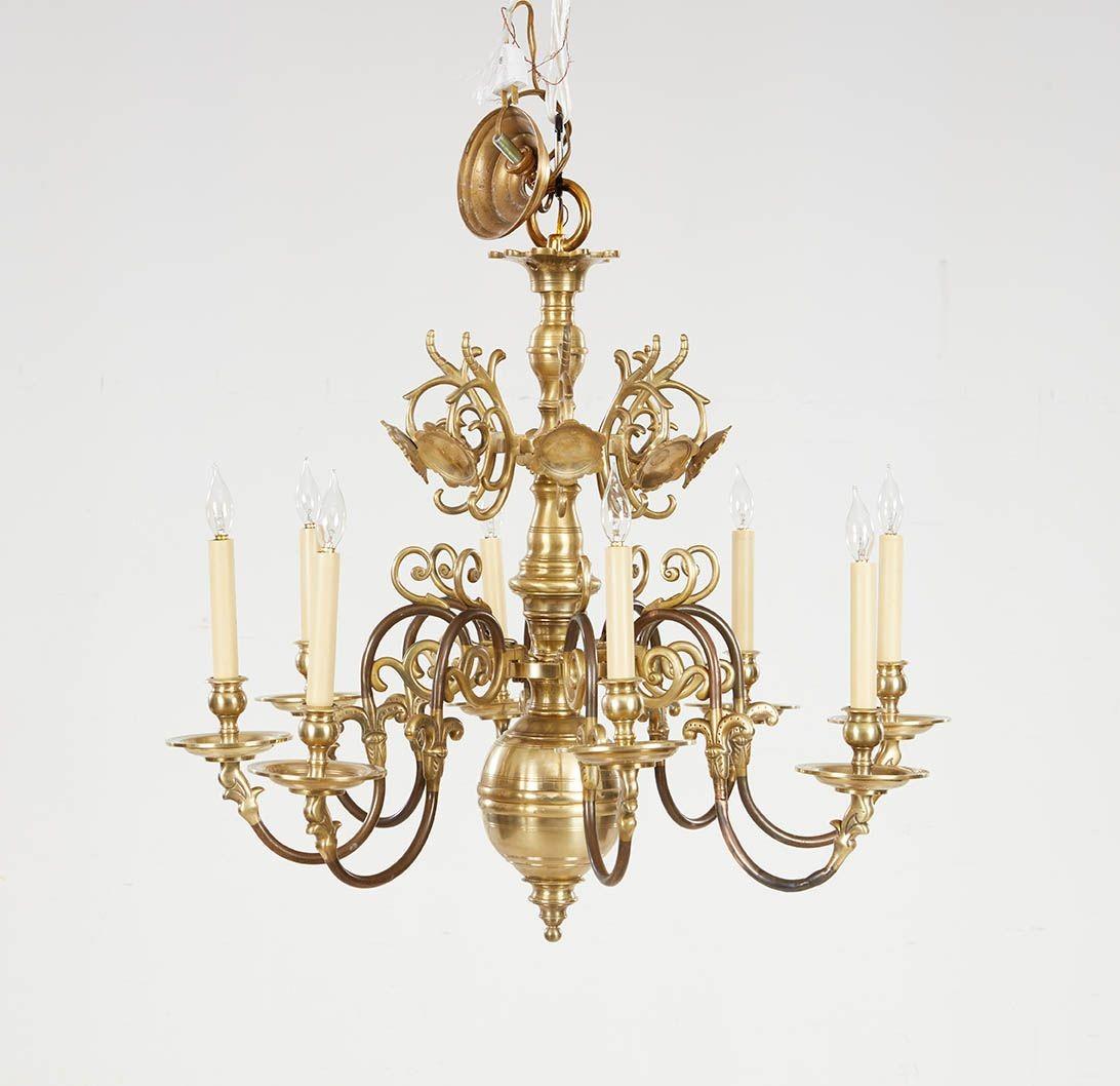 Un lampadario in ottone con un corpo in ottone tornito, otto bracci a spirale in ottone con un'attraente colorazione bicolore sui bracci e decorazioni a punzonatura sugli speroni e bobeches in ottone tornito di ampio diametro, sotto uno strato di
