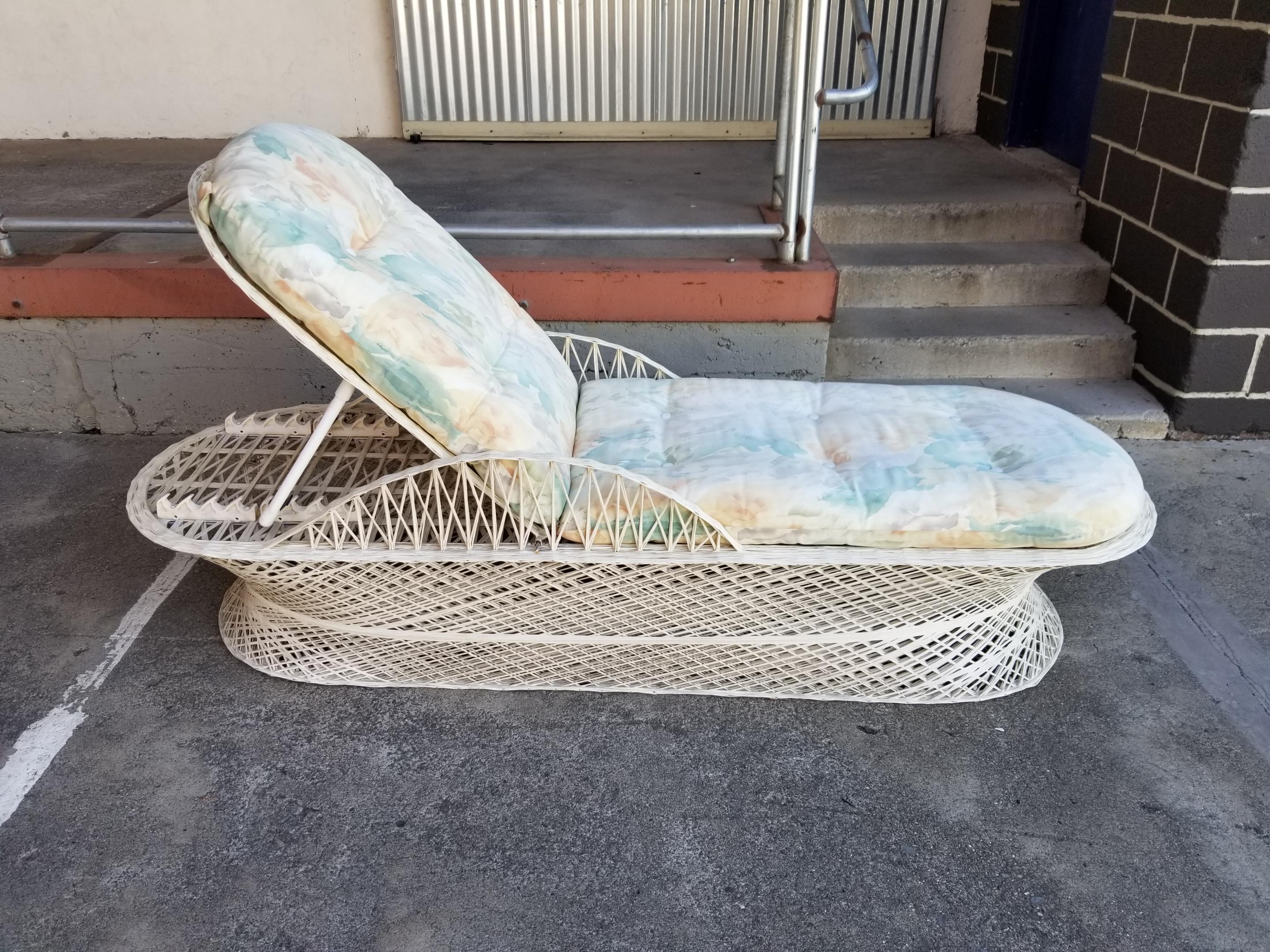 A dramatic and very comfortable spun fiberglass adjustable chaise lounge patio chair in the manner of Russell Woodard. Original paint, very sturdy. Reversible floral cushion has minor soiling. Seat back adjusts between 22.5