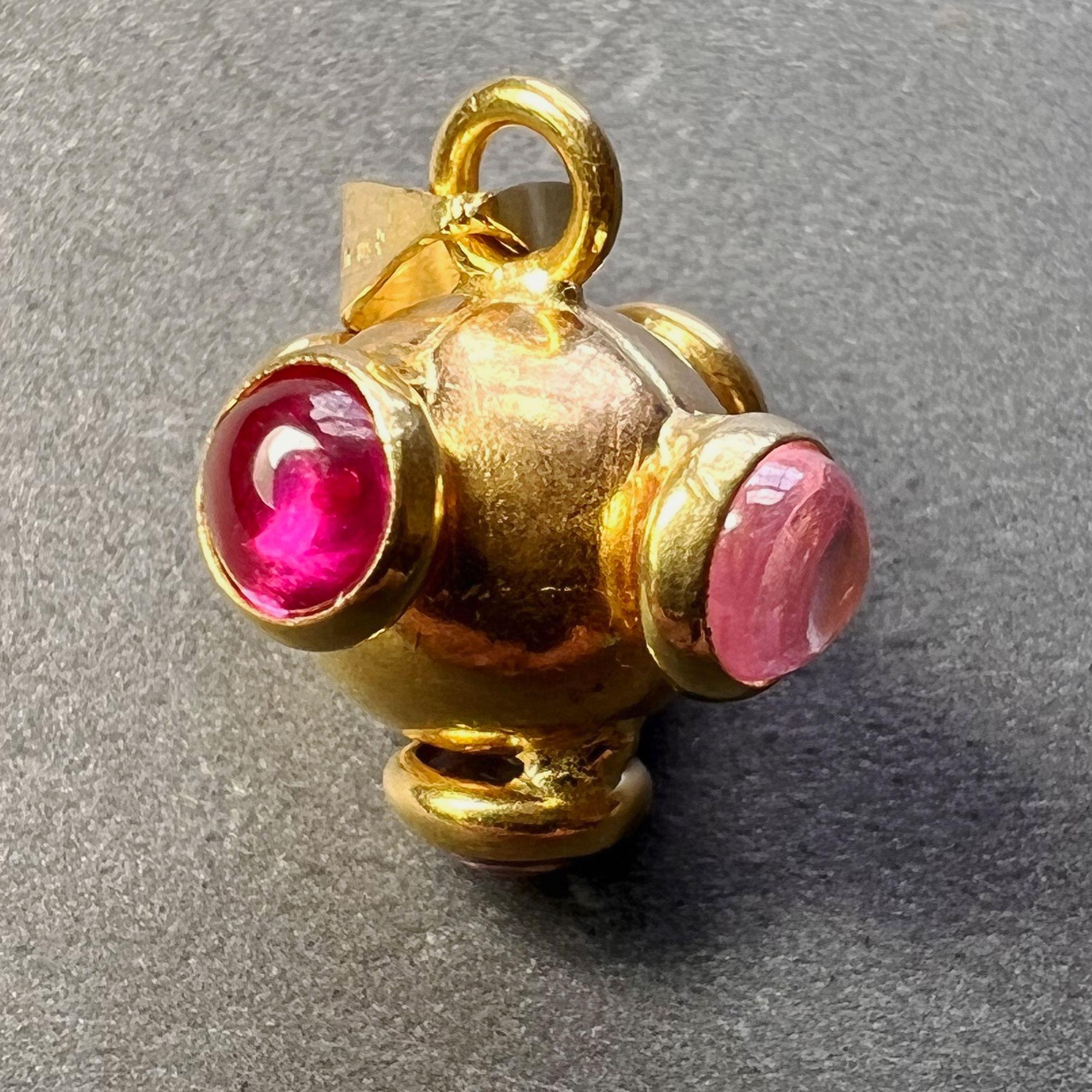 An 18 karat (18K) yellow gold charm pendant designed as a sputnik set with synthetic ruby and pink tourmaline cabochons. Stamped 750 for 18 karat gold and 589VI for Italian manufacture to the bail.
 
Dimensions: 1.3 x 1.3 x 1.3 cm (not including