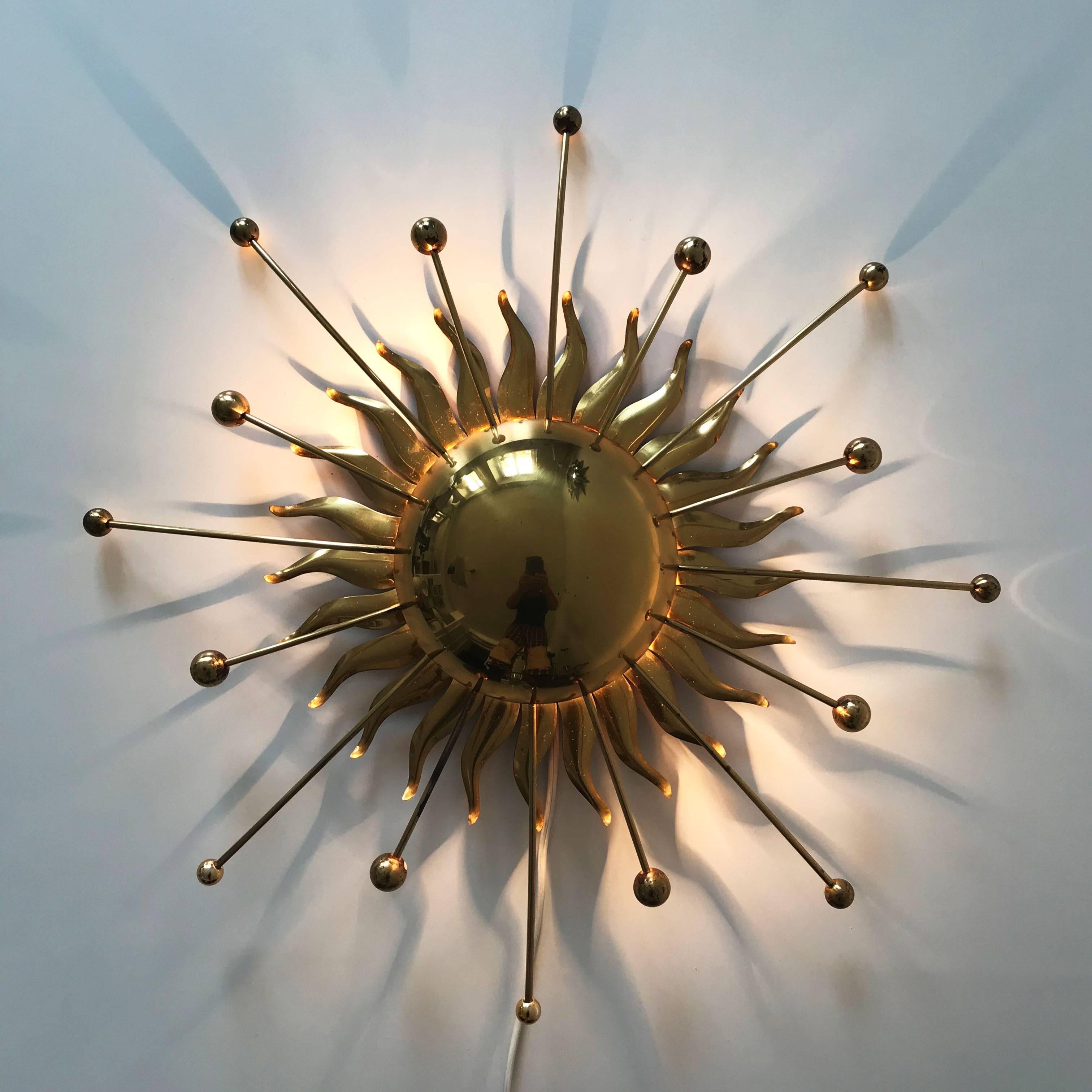 Extremely rare and stunning Mid-Century Modern Sputnik, atomic wall lamp or sconce sunburst from 1960s, Germany. Designed in shape of the sun bursting flames.
Executed completely in brass, the lamp has two E14 screw fit bulb holders. It is rewired,