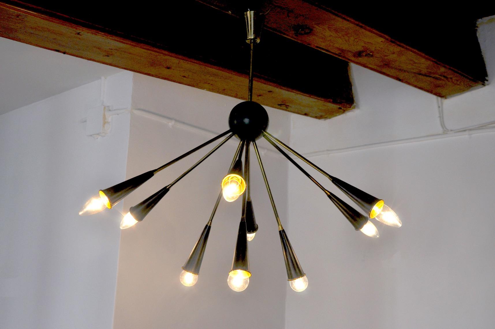 Superb sputnik chandelier in the style of stilonovo, designed and produced in italy around 1960. This chandelier is composed of 9 arms, a brass structure painted black. Rare design object that will illuminate your interior wonderfully. Electricity