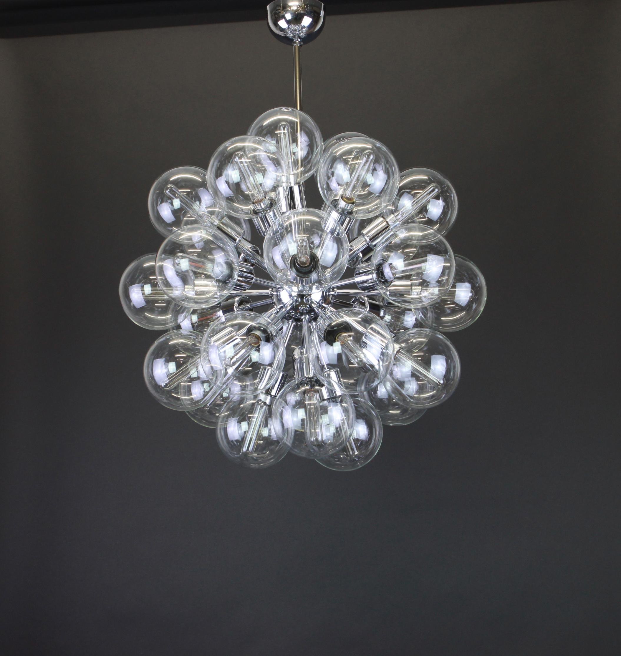 Beautiful large starburst chrome chandelier designed by Motoko Ishii for Staff Leuchten, manufactured in Germany, circa the 1960s.
It features a chrome frame with (28) transparent blown glass globes surrounding the frame creating a spectacular