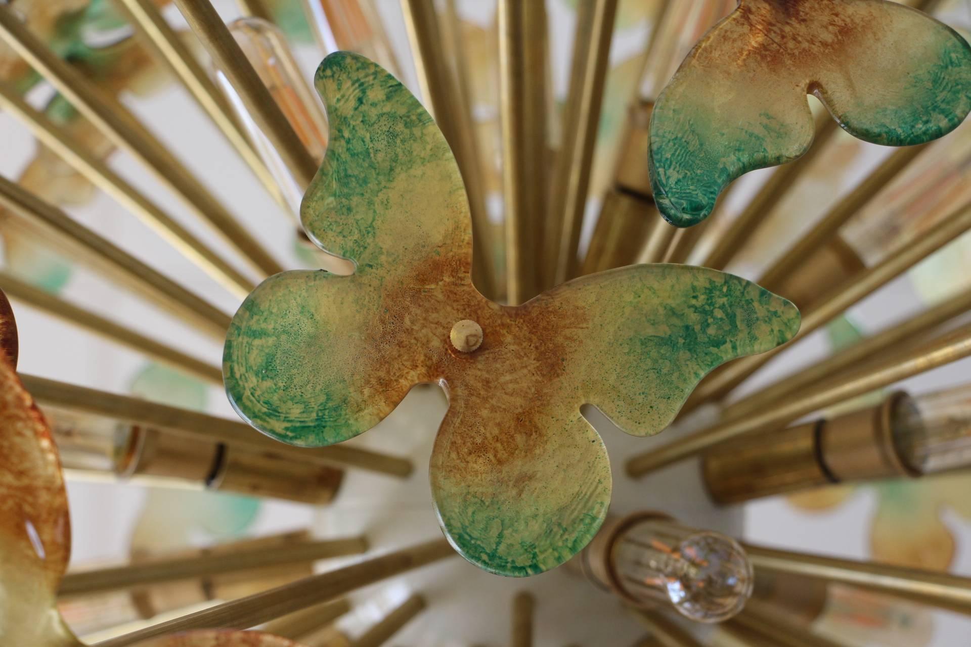 This very unusual sputnik chandelier features a multitude of brass rods, each ending with flying butterflies in Murano glass.
All the rods have got different length sothat butterflies are on different levels and it gives to this chandelier a very