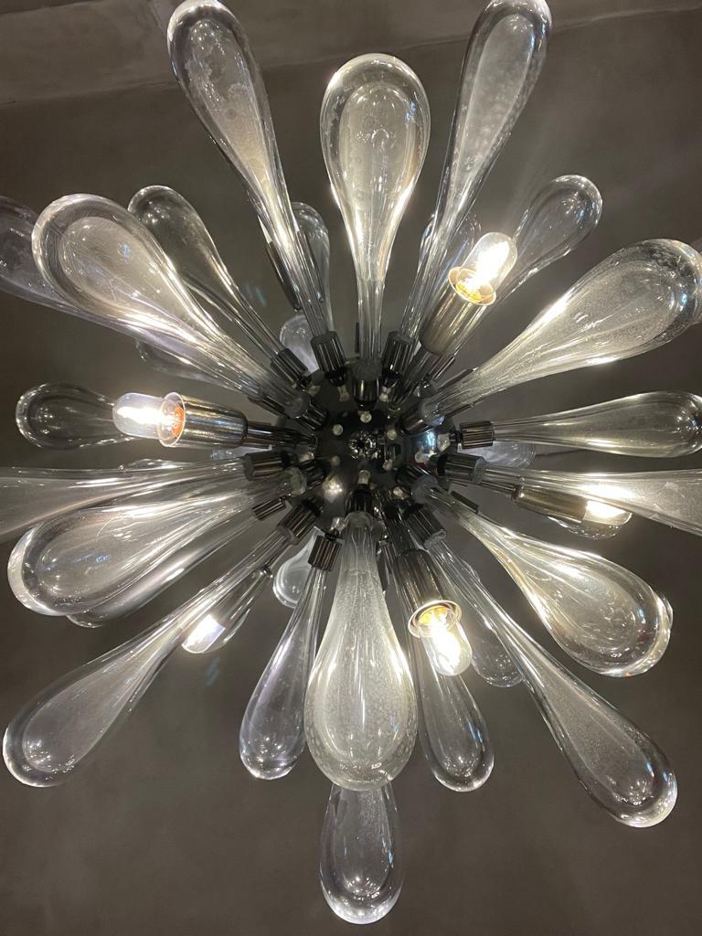 Sputnik chandelier manufactured in Italy, 1970s.
Chandelier characterized by a chromed steel sphere from which depart oblong bulbs in submerged blown Murano glass, among which emerge light bulbs.
Excellent vintage patina.