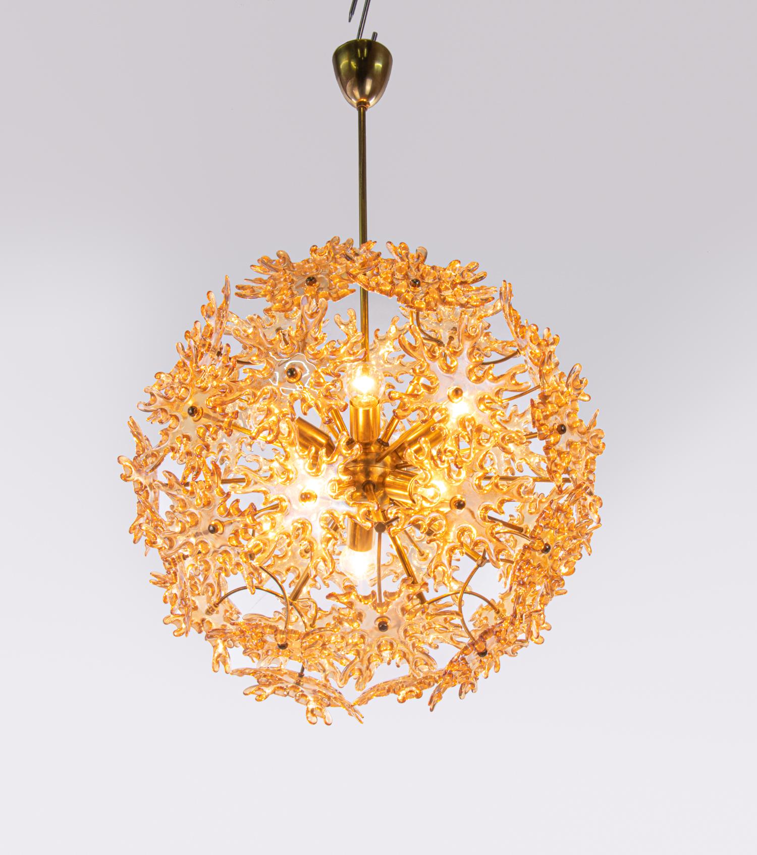 Elegante gran araña de 10 luces con estrellas de cristal de Murano de color ámbar iridiscente sobre un marco de latón dorado. La lámpara de araña ilumina maravillosamente y ofrece mucha luz. Gema de la época. Un verdadero punto de atracción incluso