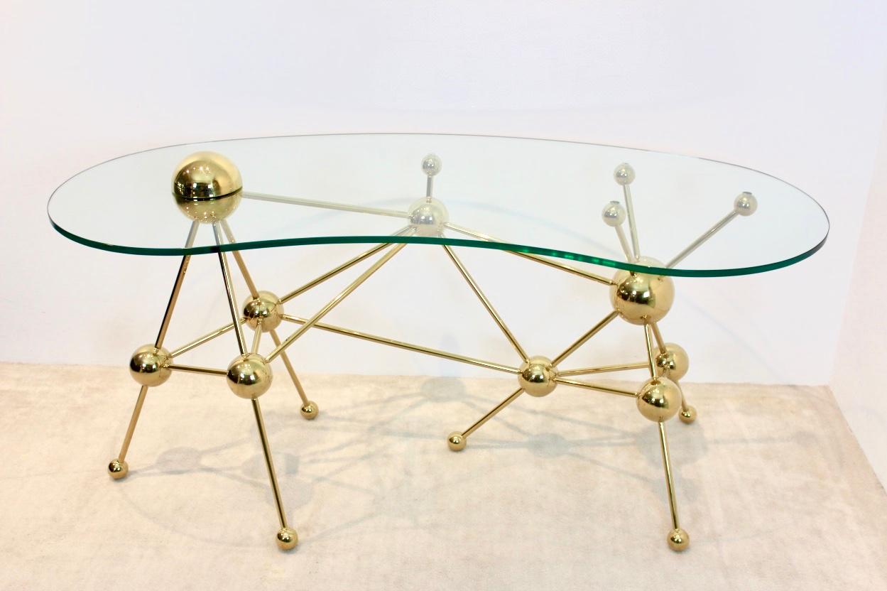 Unique Sputnik leg table or desk, 1990s 'Hollywood style. Simple, sophisticated and very nice design made out of steel/brass legs with a beautiful thick glass top. High decorative piece in Hollywood style. Comes from a famous Dutch entrepreneur and