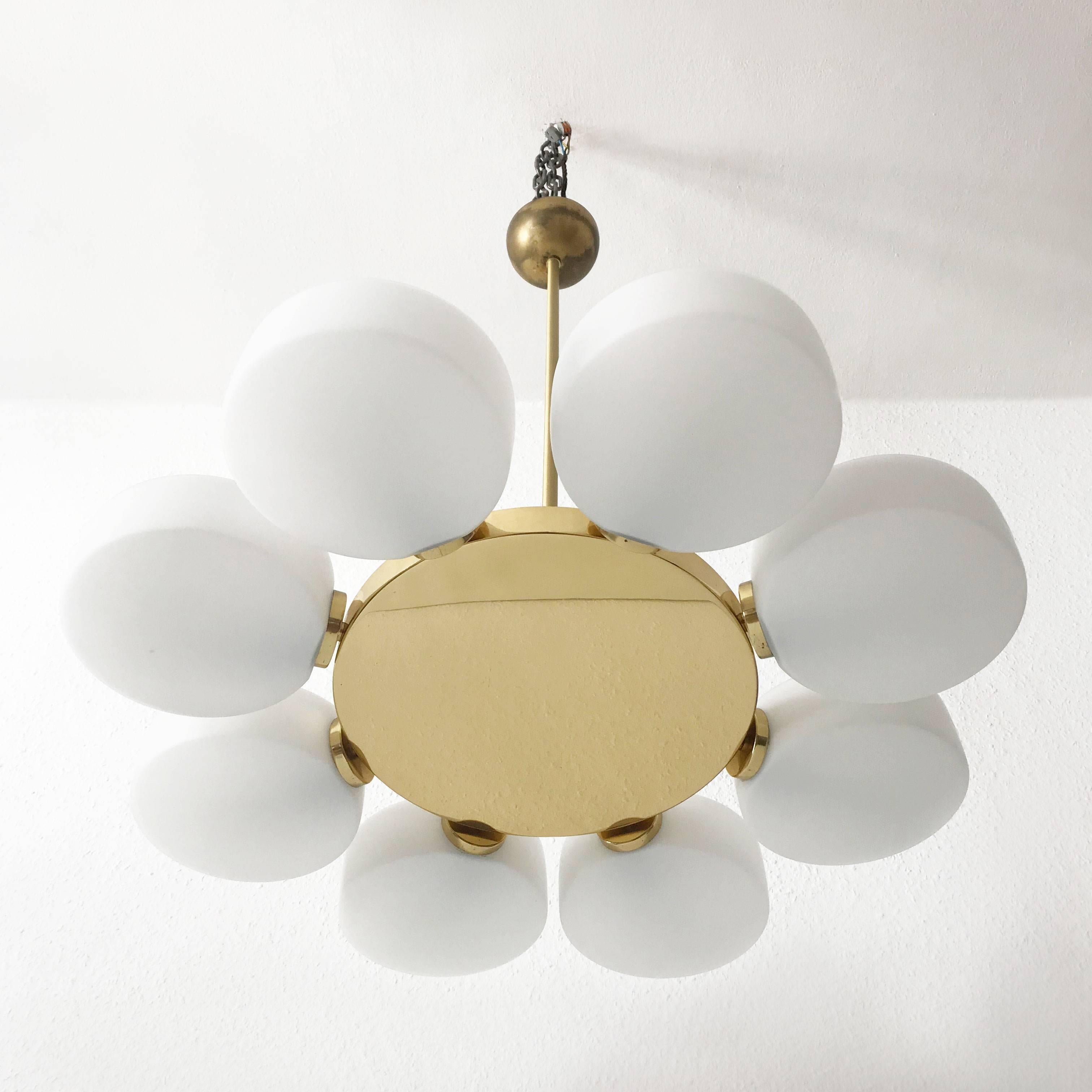 Spectacular eight-armed Mid-Century Modern Sputnik disk chandelier or pendant lamp by Kaiser Leuchten, Germany, 1960s.
The polished brass body holds eight opaline glass disks which can be rotated so that the chandeliers look can be chanced if