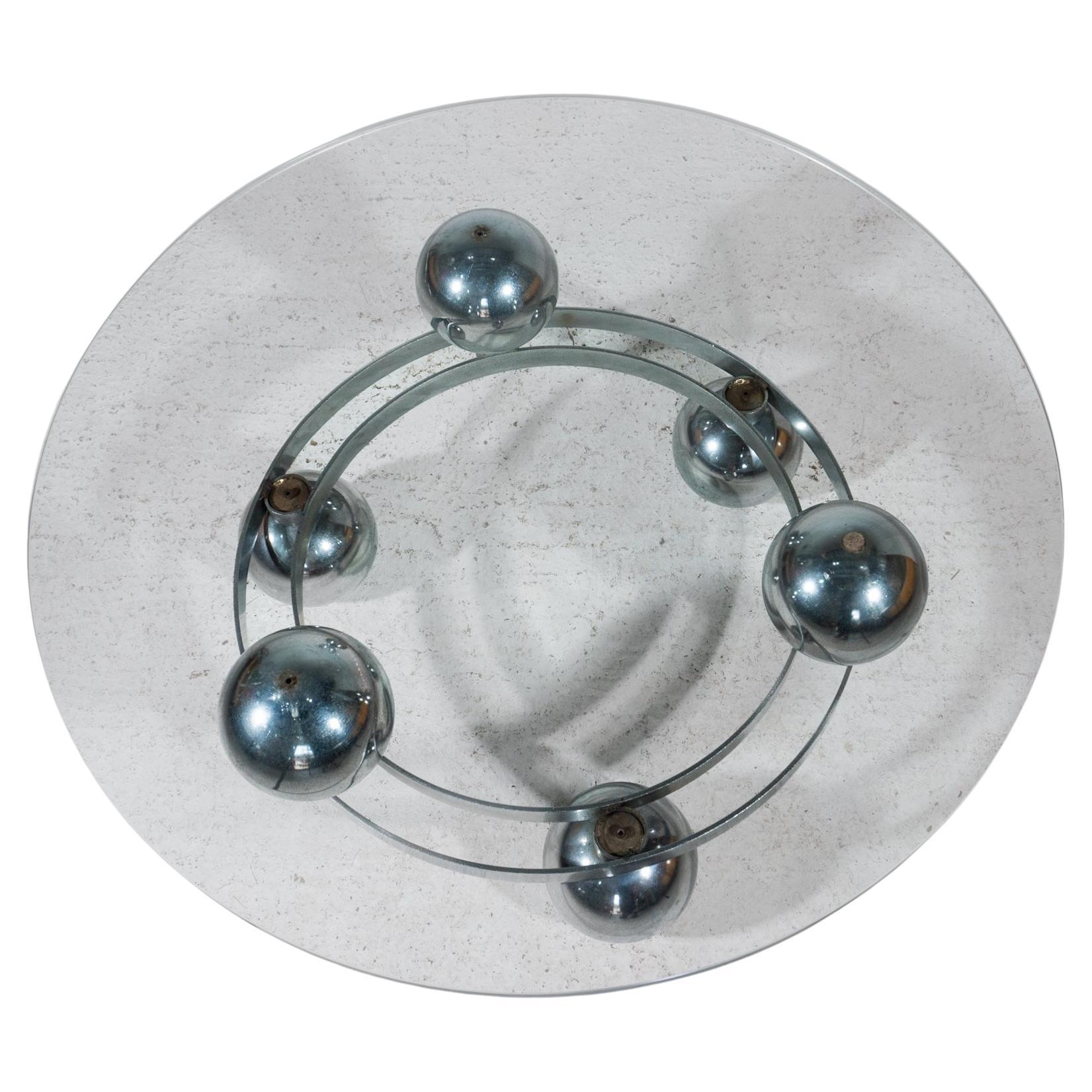 Ein dynamischer, runder Couchtisch aus verchromten Metallkreisen, verbunden mit sechs verchromten Metallkugeln und einer runden, klaren Glasplatte. Entworfen und hergestellt in Deutschland, 1960er Jahre, Designer unbekannt.
