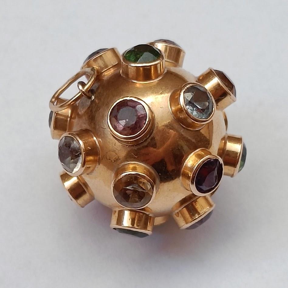 Un grande pendente/ciondolo a forma di Sputnik in oro 18k con gemme colorate.
Due piccoli marchi illeggibili sul salto.
Buone condizioni, nessun difetto

Diametro 2 cm (circa)
Peso 6,72 grammi

Il lancio dello Sputnik 1 il 4 ottobre 1957 segnò