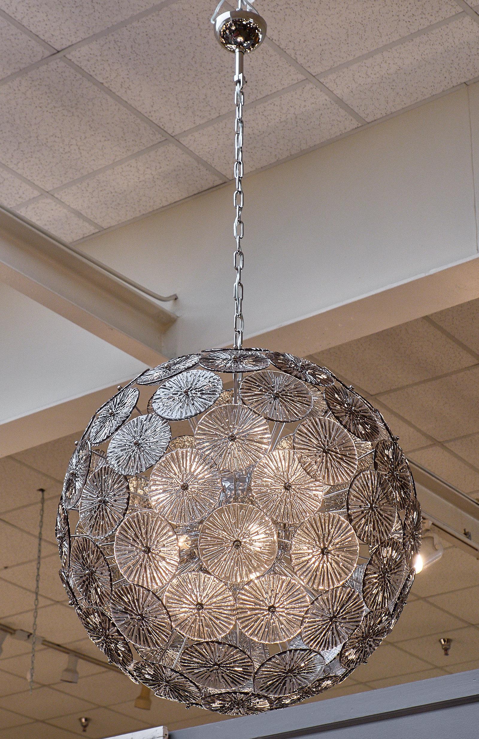 An Italian smoked Murano glass Sputnik chandelier. This fixture has multiple smoked glass circular elements, each handblown using the “stampato” technique. We couldn’t resist the soft glow and the feel of strong elegance and refinement. This
