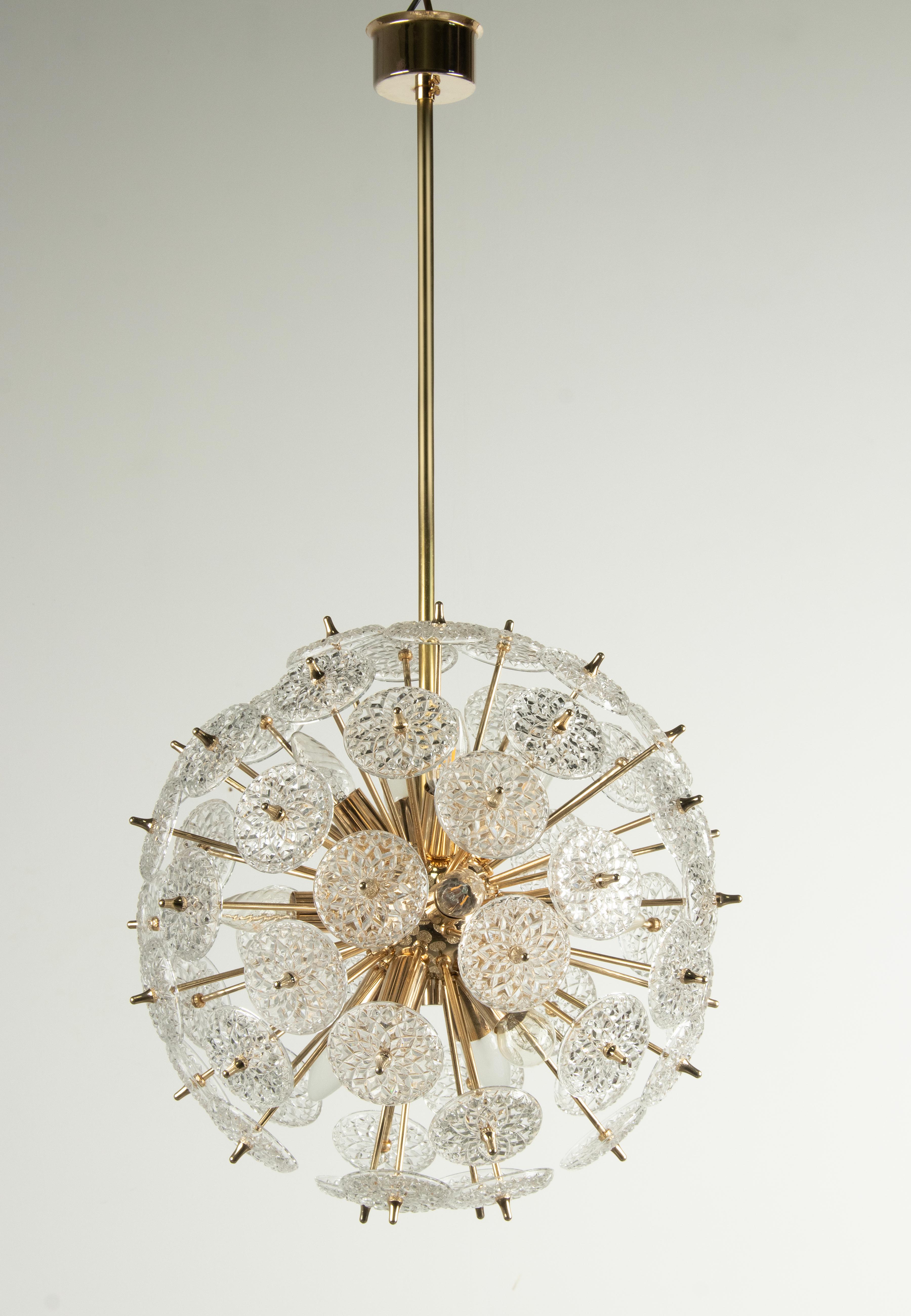 Beautiful ceiling lamp, a Sputnik model with many glass disks. The disks are cut and therefore you see a nice reflection of the light shining through this lamp. The interior is made of polished brass colored metal with twelve E14 lamp sockets. This