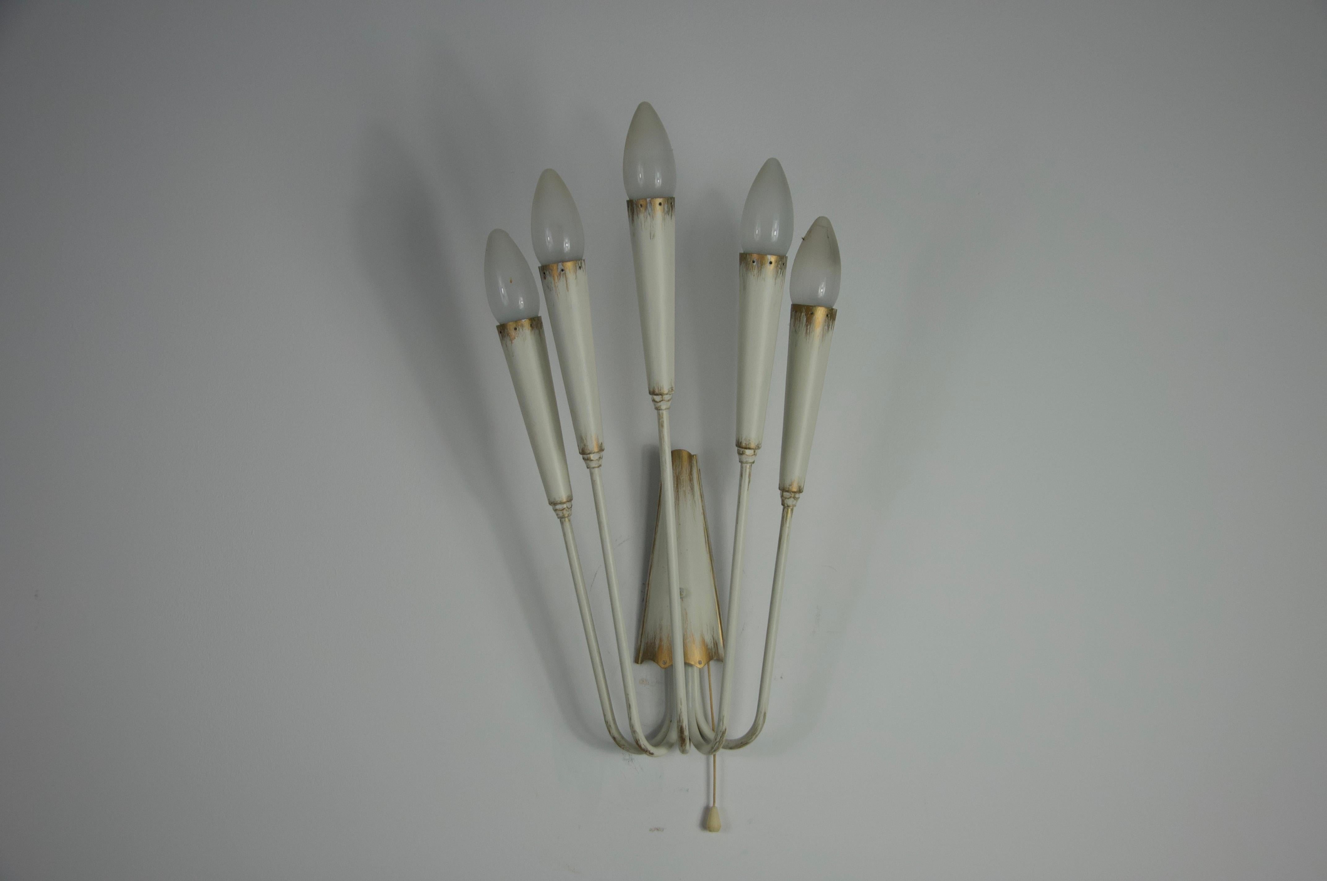 Cette étonnante applique murale de style Sputnik des années 1960 est un bel exemple du design italien du milieu du siècle dernier. Fabriquée en métal, elle présente des bras élégamment allongés qui se rétrécissent en pointes perforées, créant un