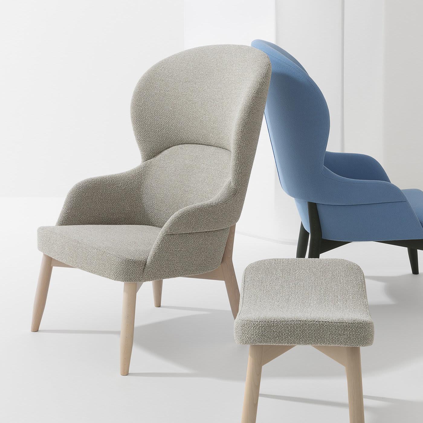 This elegant design defined by soft curves is an invitation to relax while sipping a good glass of wine. Four tapered legs in whitened beech - same material composing the armchair's frame - sustain the welcoming seat (height 43 cm) fully enveloped