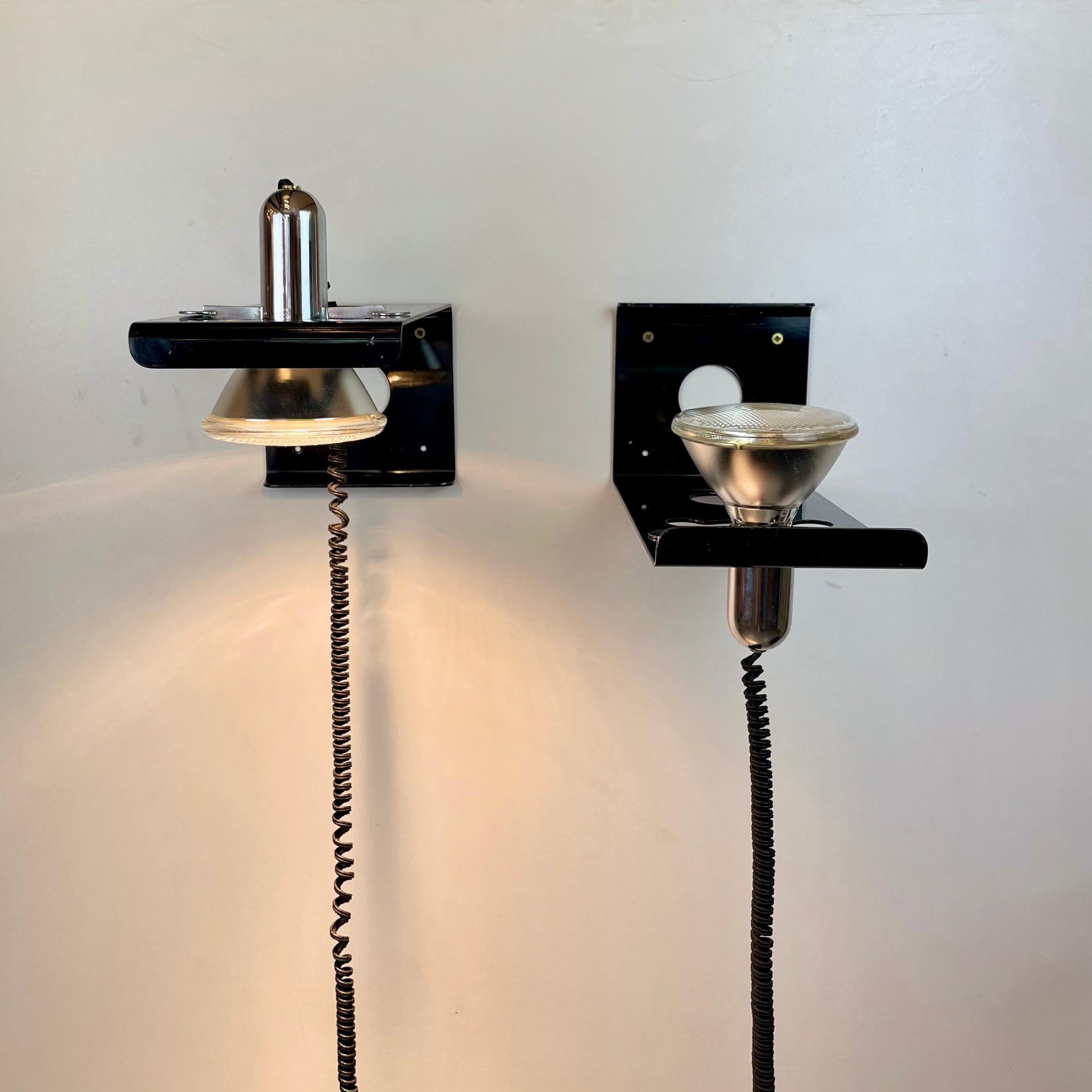 Pair of Italian wall lamps named 'Squadra' and composed of a black lacquered metal body and a shiny chrome suspended spotlight with a black pigtail wire. Adjustable up or down. Designed by Ezio Didone for Valenti in the 1970s.
-
Designed by: Ezio