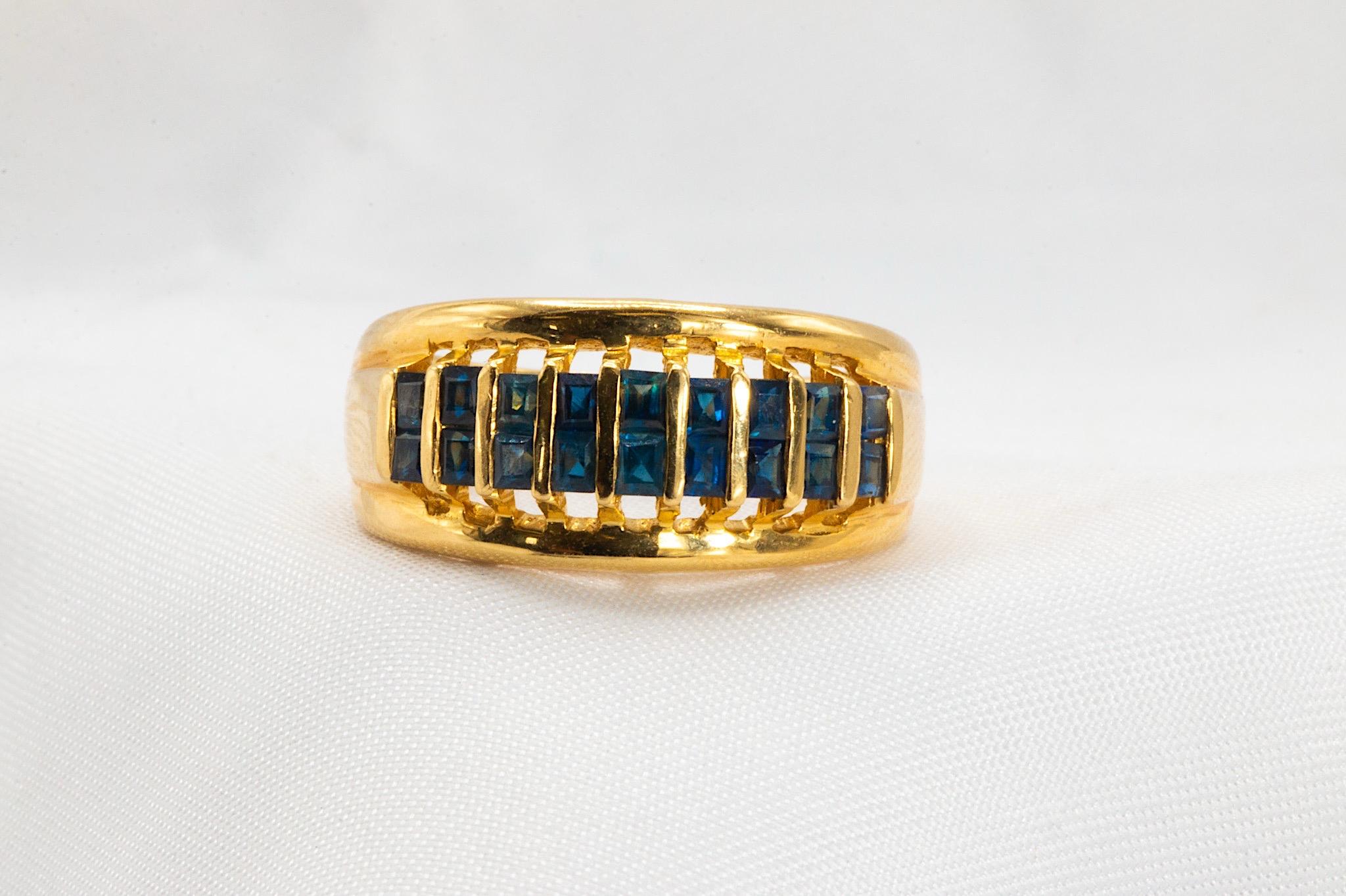 This 18K yellow gold band is truly one-of-a-kind. Weighing 7.1 grams with approximately 0.80 carat in natural square-cut blue sapphires, this uniquely architectural ring has nine grooves and a tall dome-like profile.

Tapering from 9.5 to 3.6mm, it