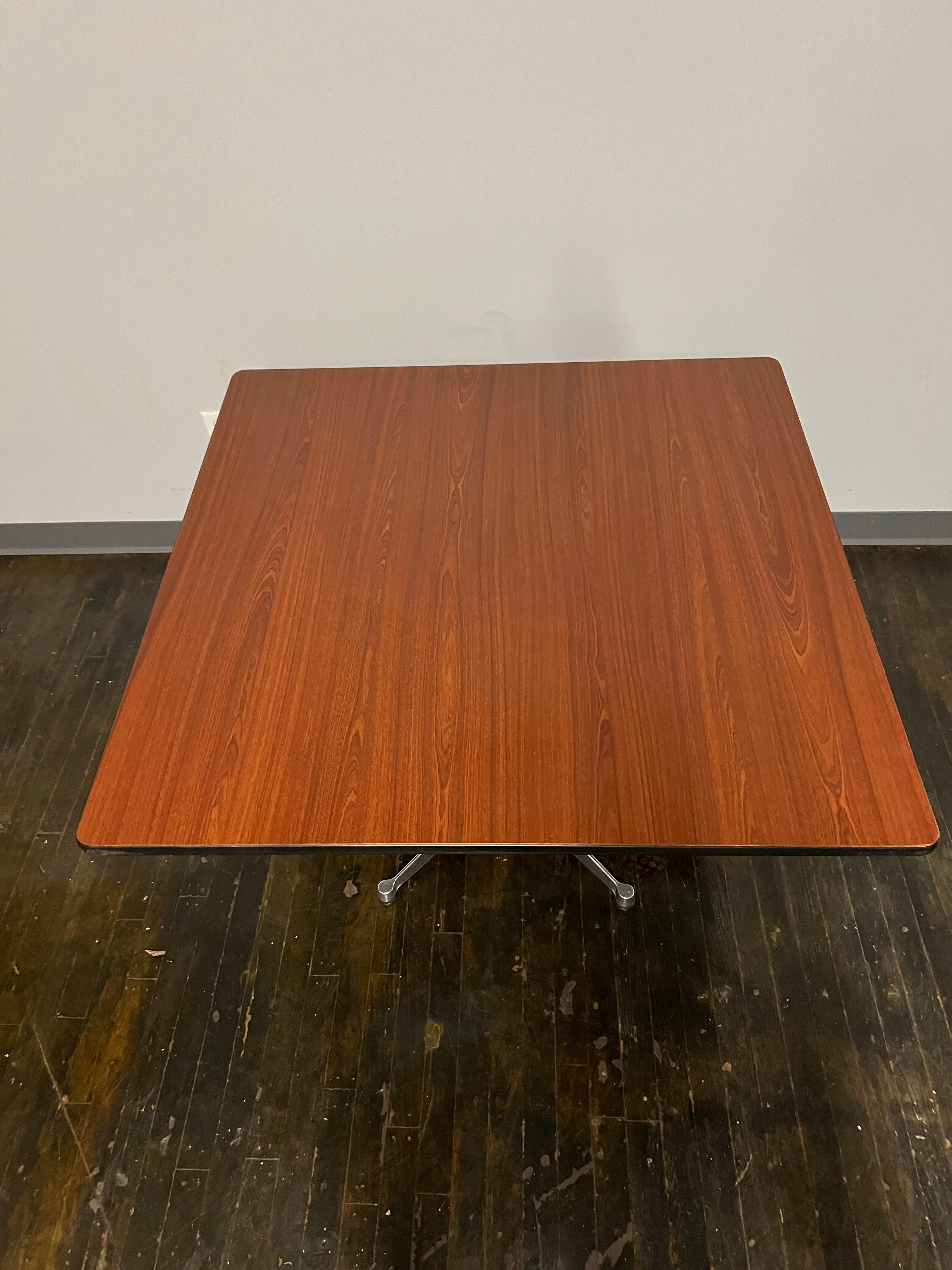 A contract grade table designed by Charles and Ray Eames circa 1955.  It features a chrome pedestal base.  The top appears to be a walnut laminate.  

The table can be found in  Eames Design: The Work of the Office of Charles and Ray Eames, Neuhart,