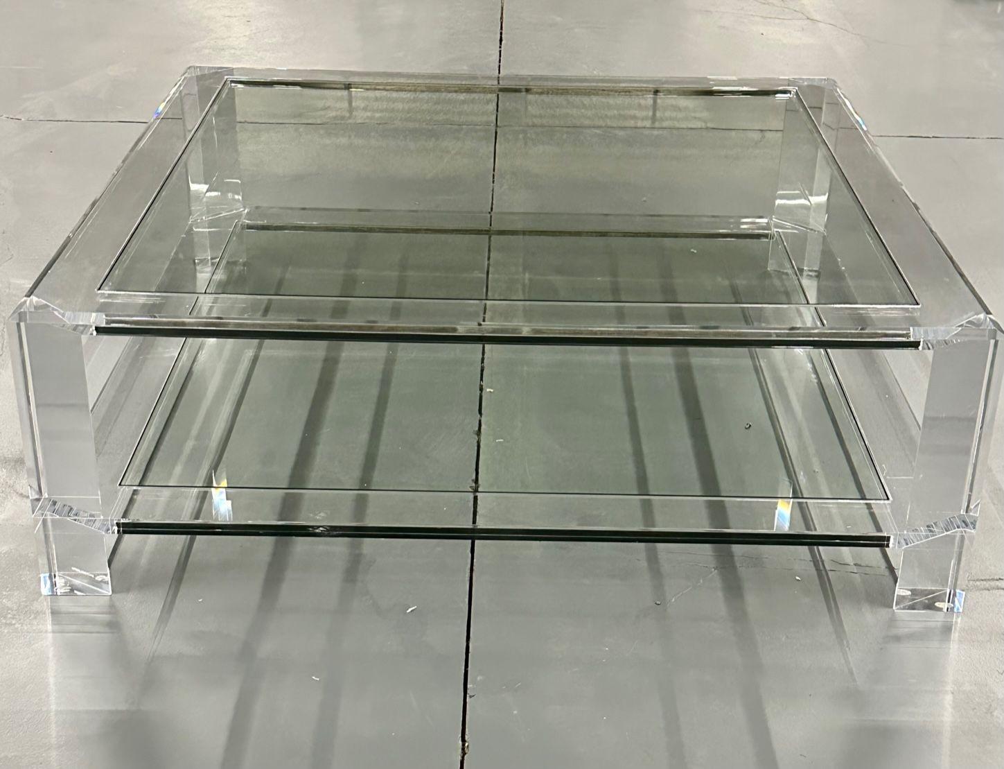 Modern two-tier square acrylic and glass coffee / cocktail table, Interlude home.
Handsome and commanding, the acrylic and glass surrey grand square cocktail table adds contemporary flair to any living area. Seen here at a substantially discounted